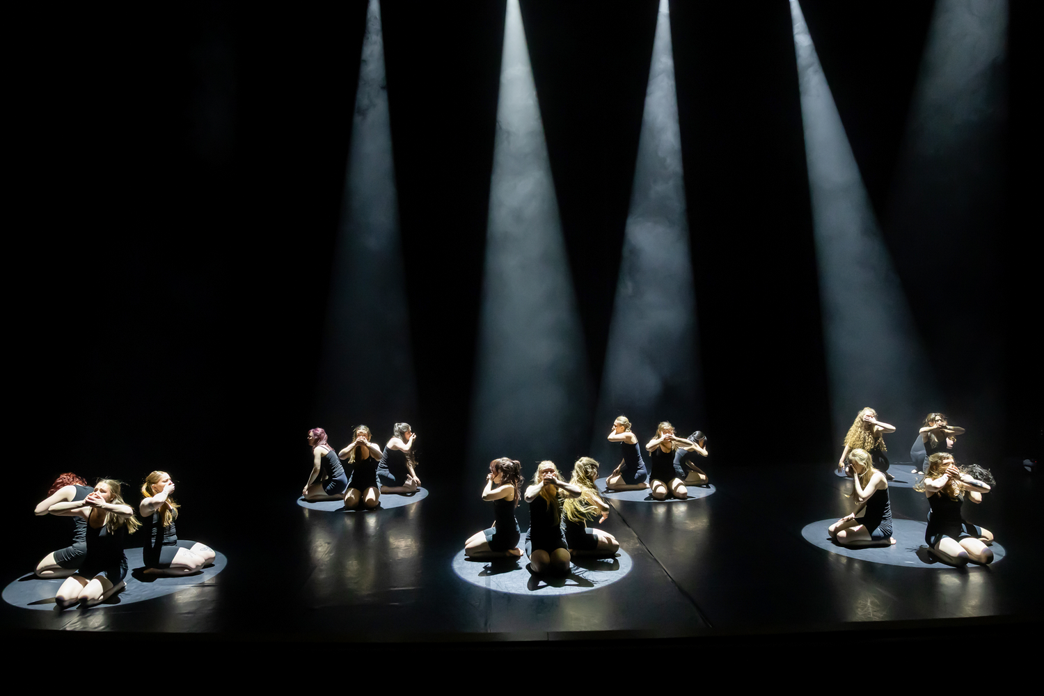 Dansuppvisning med Dansårets och dans-pedagogiska från Karlstads Universitet. Vårshow. Grupperingar i olika ljuskäglor. Alla svartklädda.