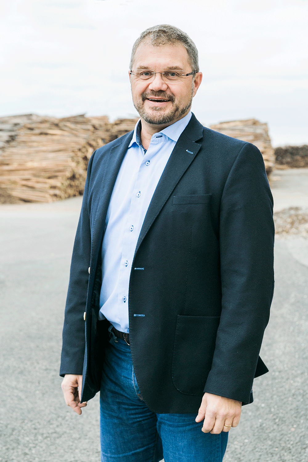 Företagsporträtt på Mikael Forslund på Andritz framför timmer.