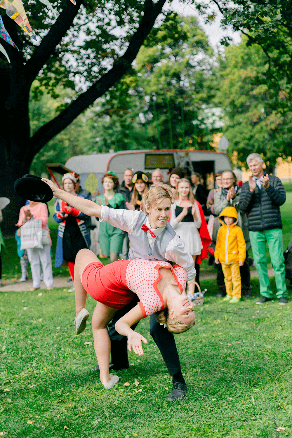Lindyhop dans i museumparken. Hebbe-sister. Färgglatt par med publik bakom sig.