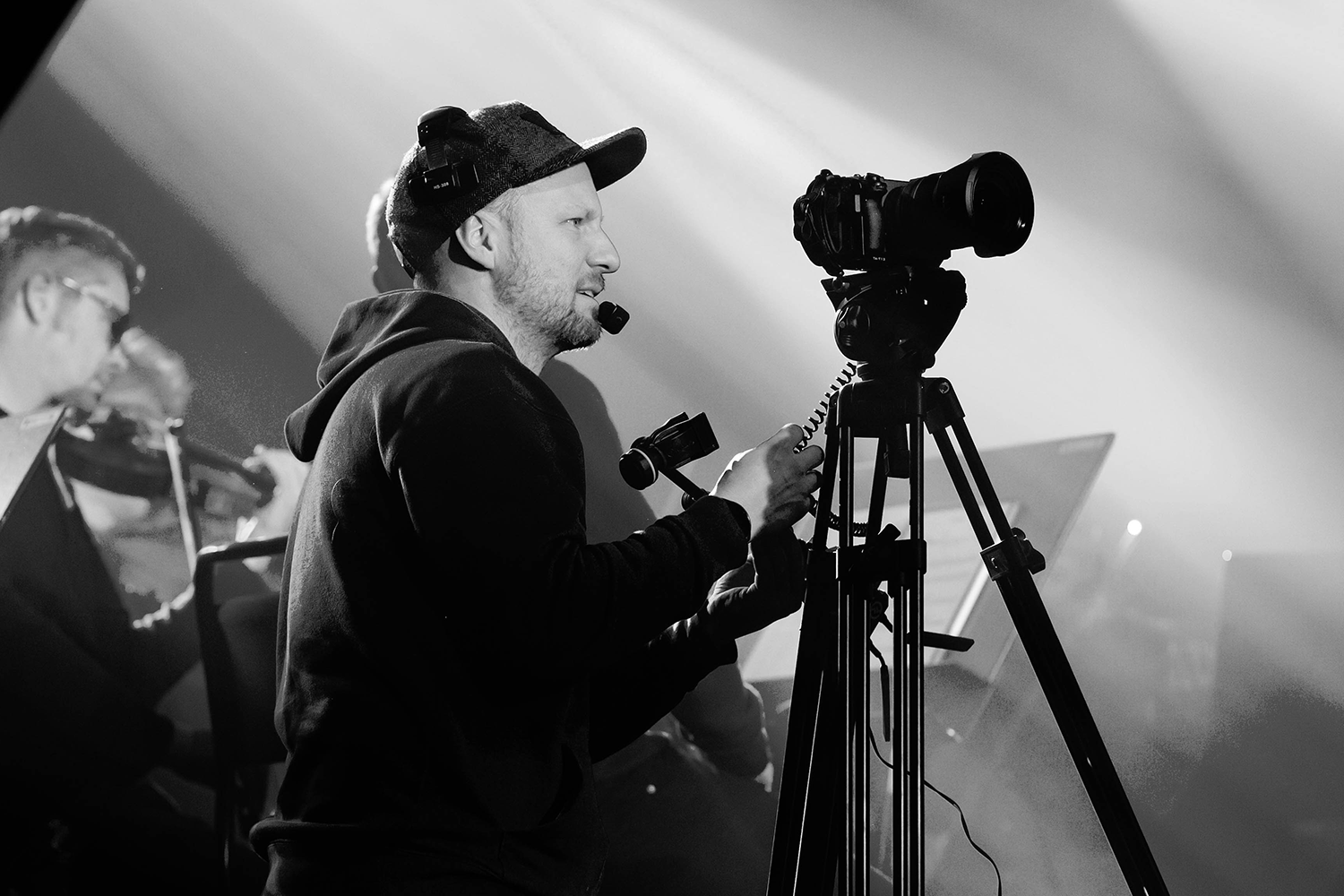 Verksamhetsbild på fotografen Michael Jämtner. Han filmar med sin kamera. Svartvitt.