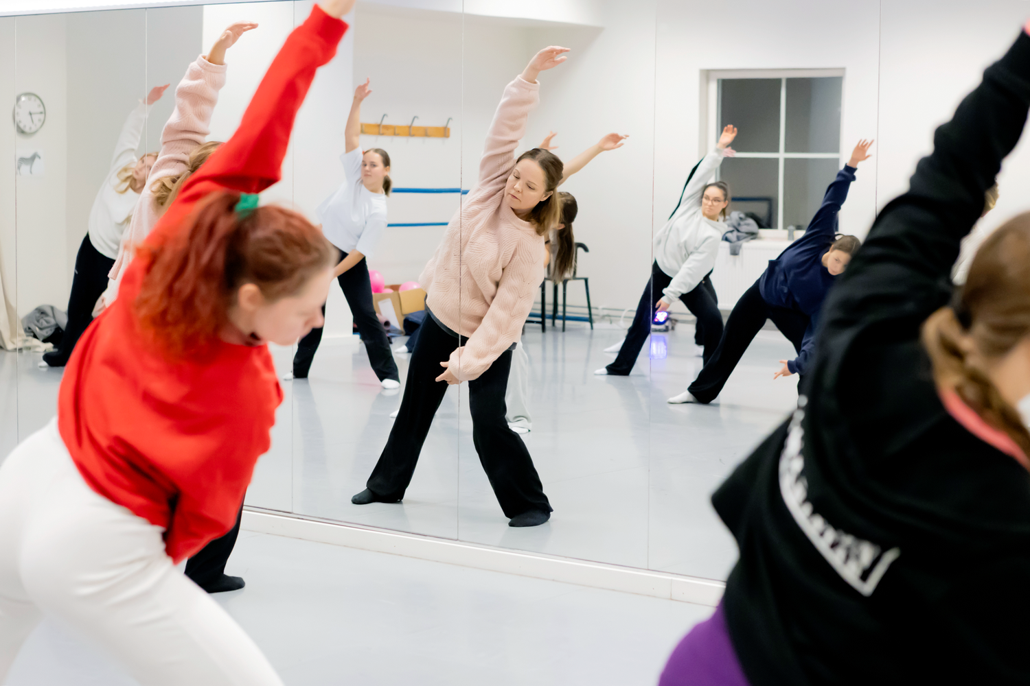Danslektion på Dansstudion i avancerad jazz med Ia Pettersson. Ia och elverna sträcker ut sin armar för att stretcha vänstersidan.