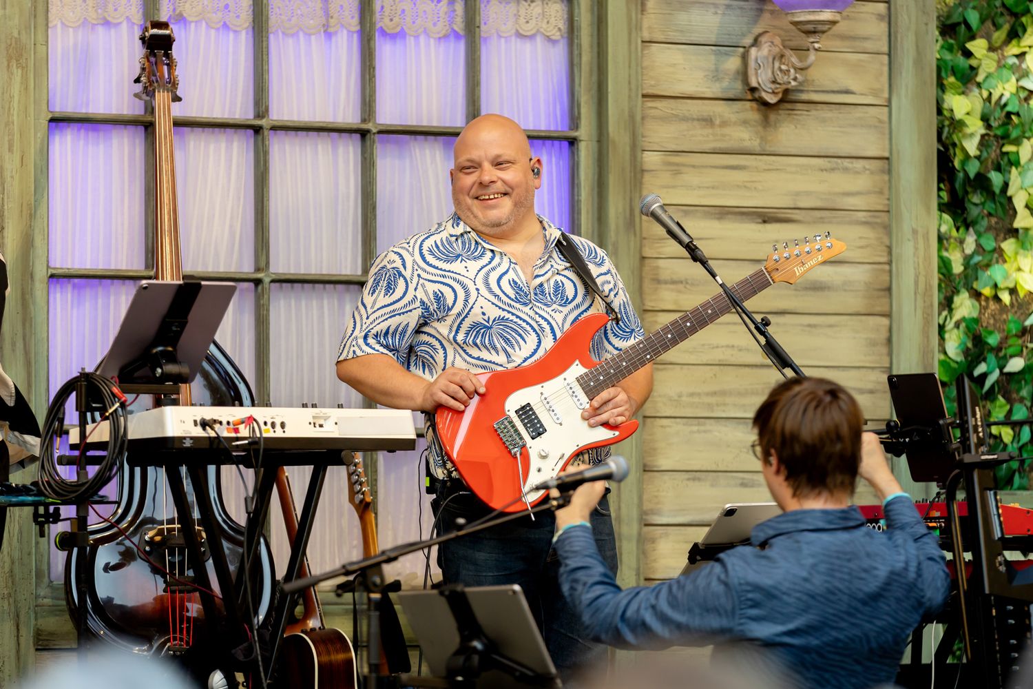Musikalkväll med Peter Johansson o Emmi Christensson. Pelle Holmberg ler och står med röd/vit gitarr.