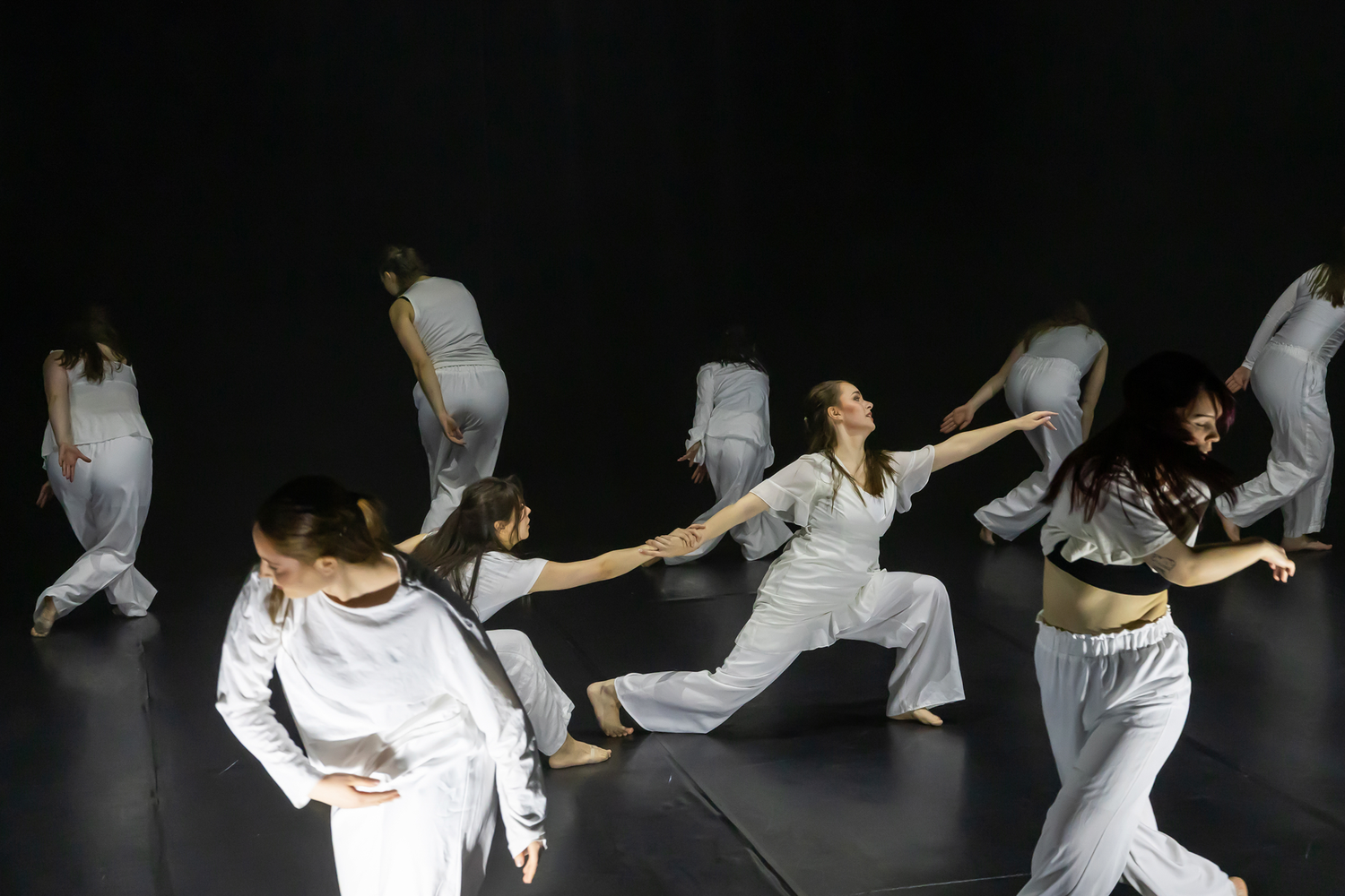 Dansuppvisning med Dansårets och dans-pedagogiska från Karlstads Universitet. Vårshow. En dansare sträcker sig ifrån en annan dansare. Koreo