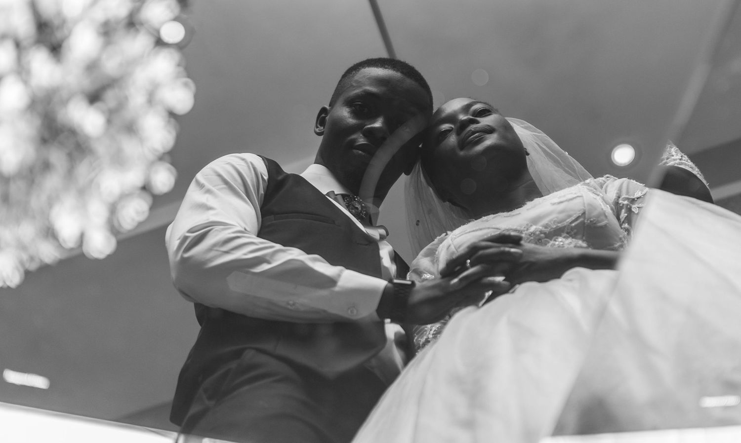 Low angle black and white photo of a bride and groom dancing at their wedding.