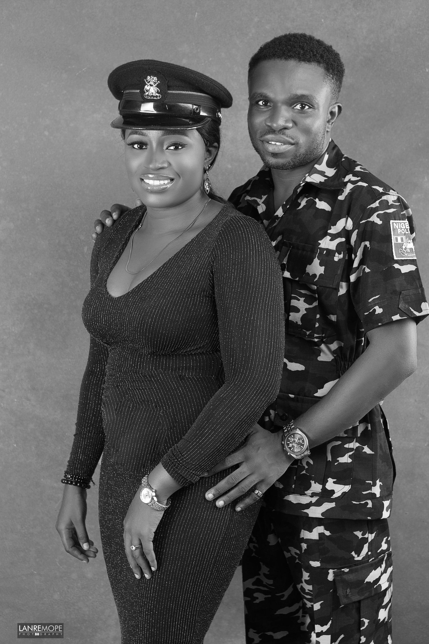 Nigerian couple posing in military uniform for a black and white studio portrait.