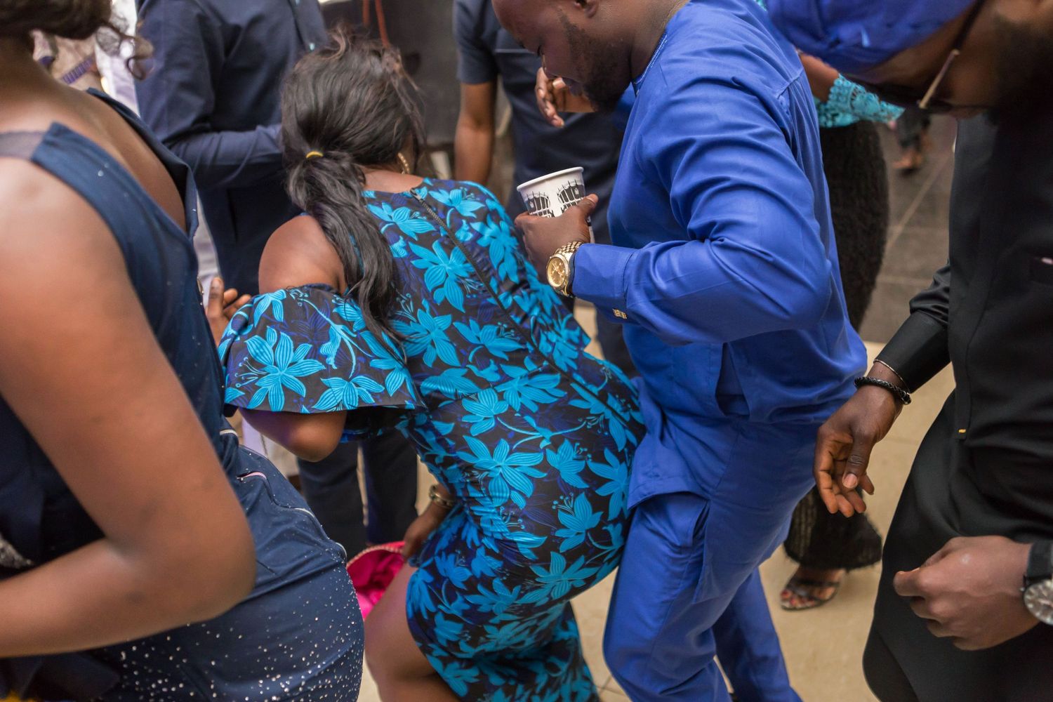 Guests dancing in colorful attire at a lively African celebration or wedding reception.