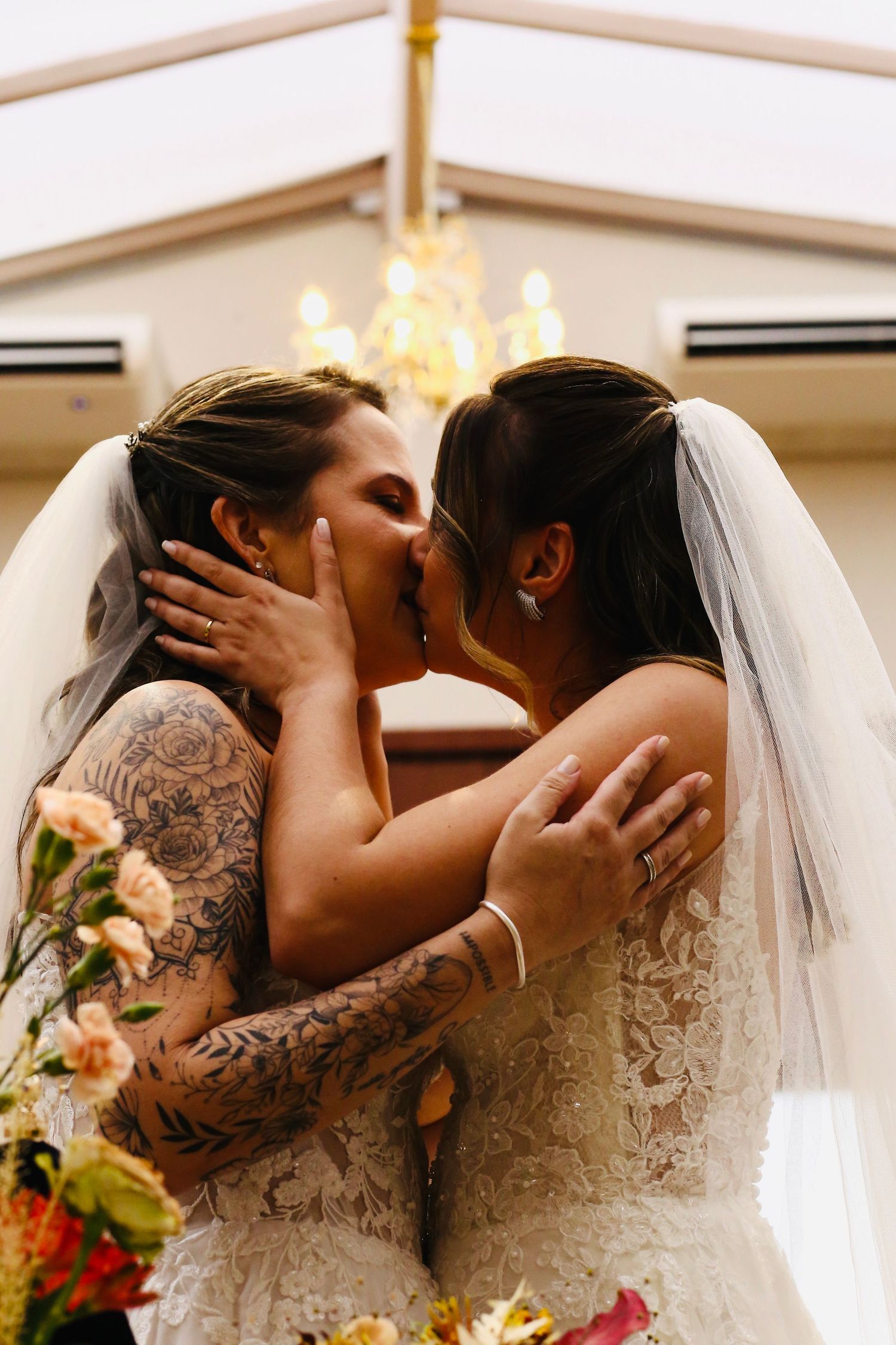 Beijo de duas noivas durante a cerimônia de casamento.