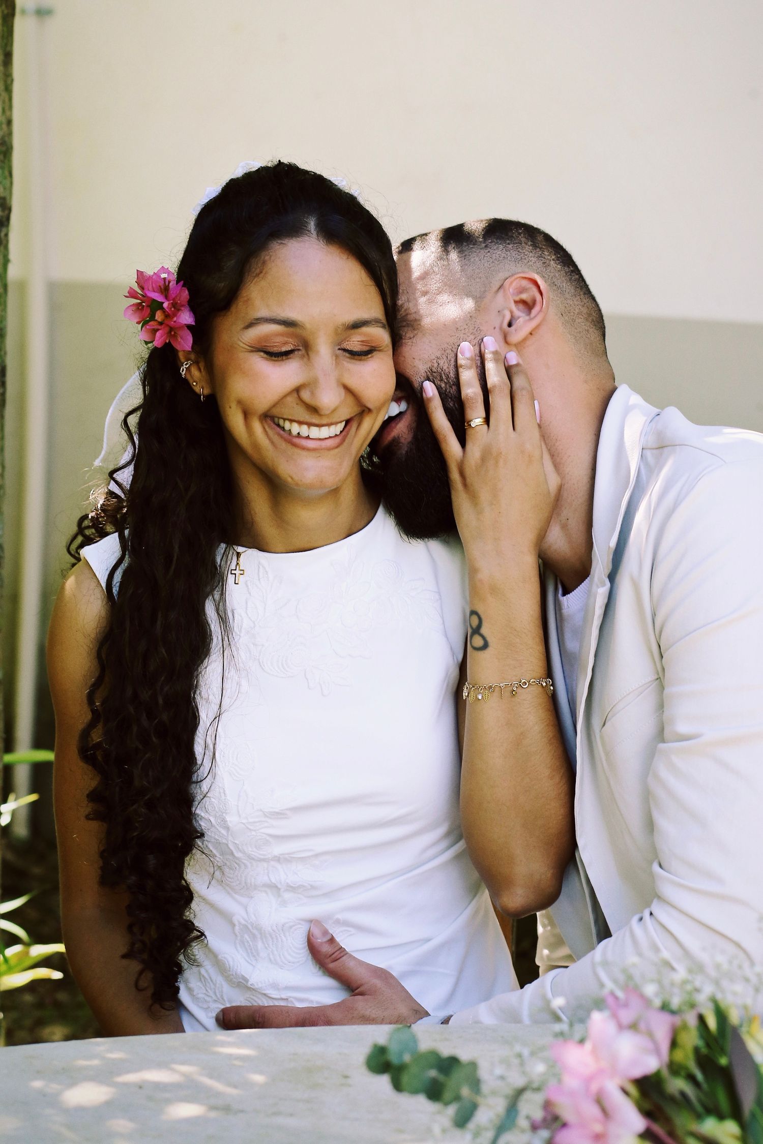 Casal abraçado sorrindo durante ensaio fotográfico.