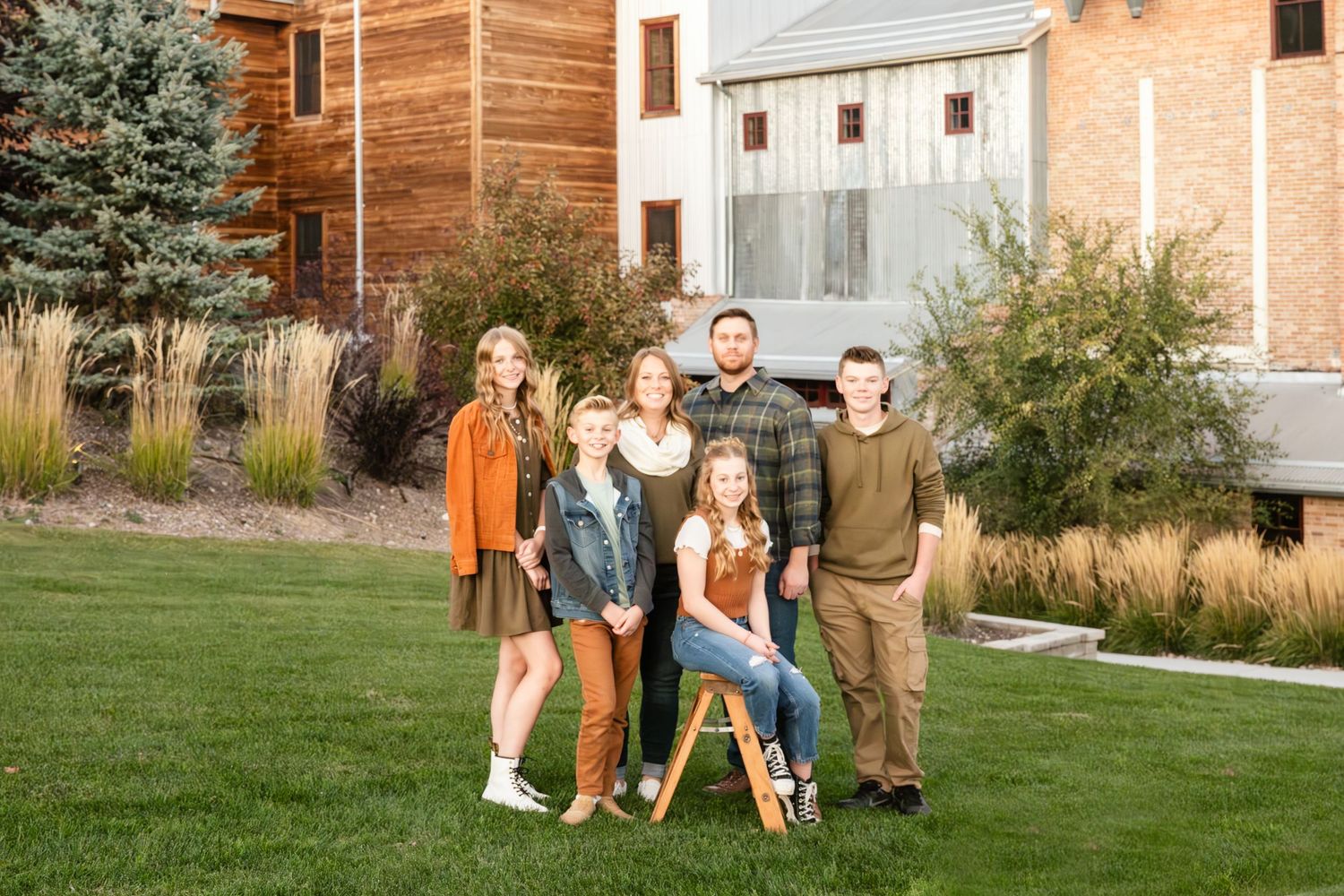 Happy family posing together outdoors during a natural lifestyle family portrait session in a beautiful Utah neighborhood.