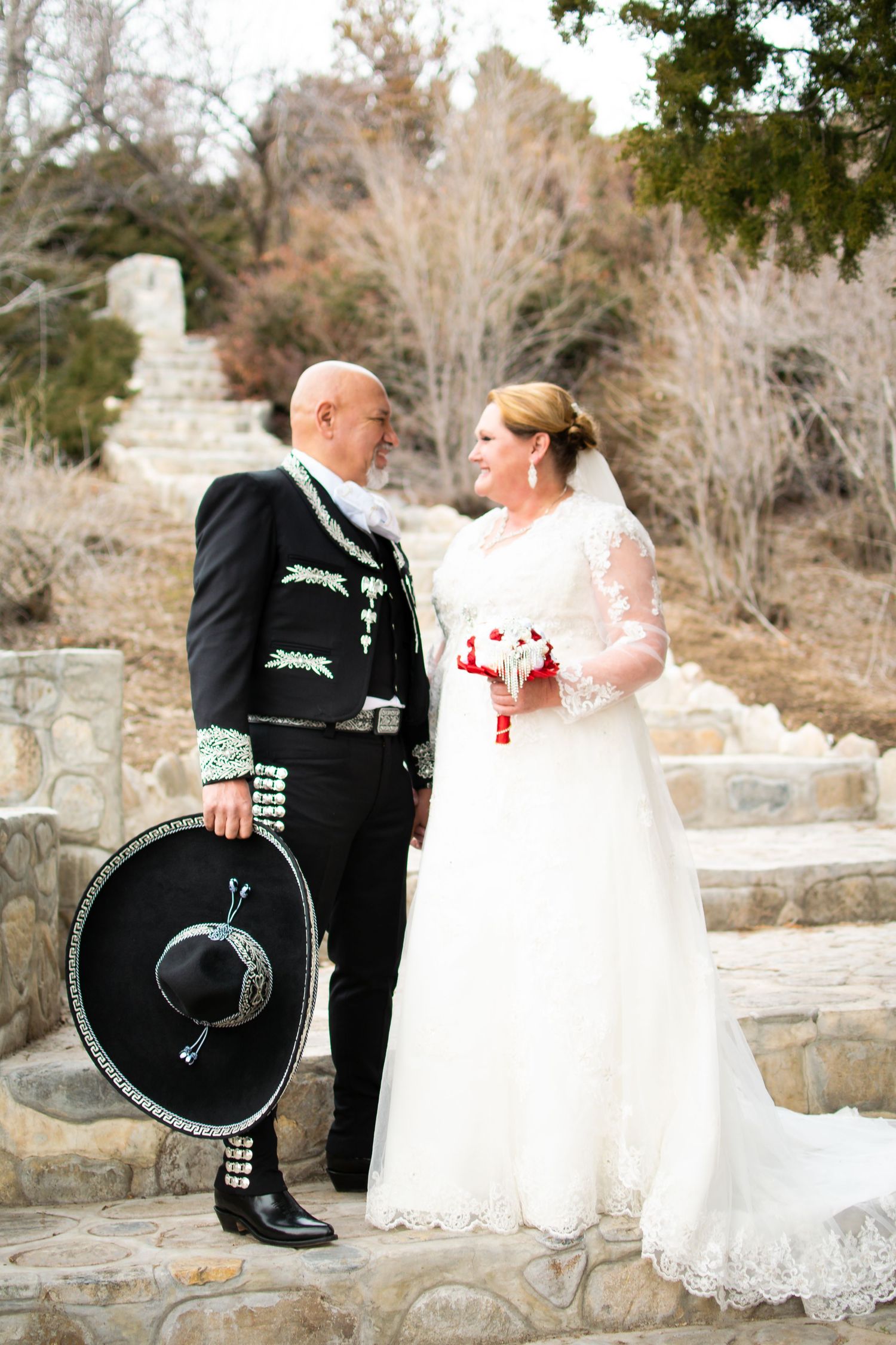 Bride and groom smiling together during outdoor wedding portraits after their temple ceremony.