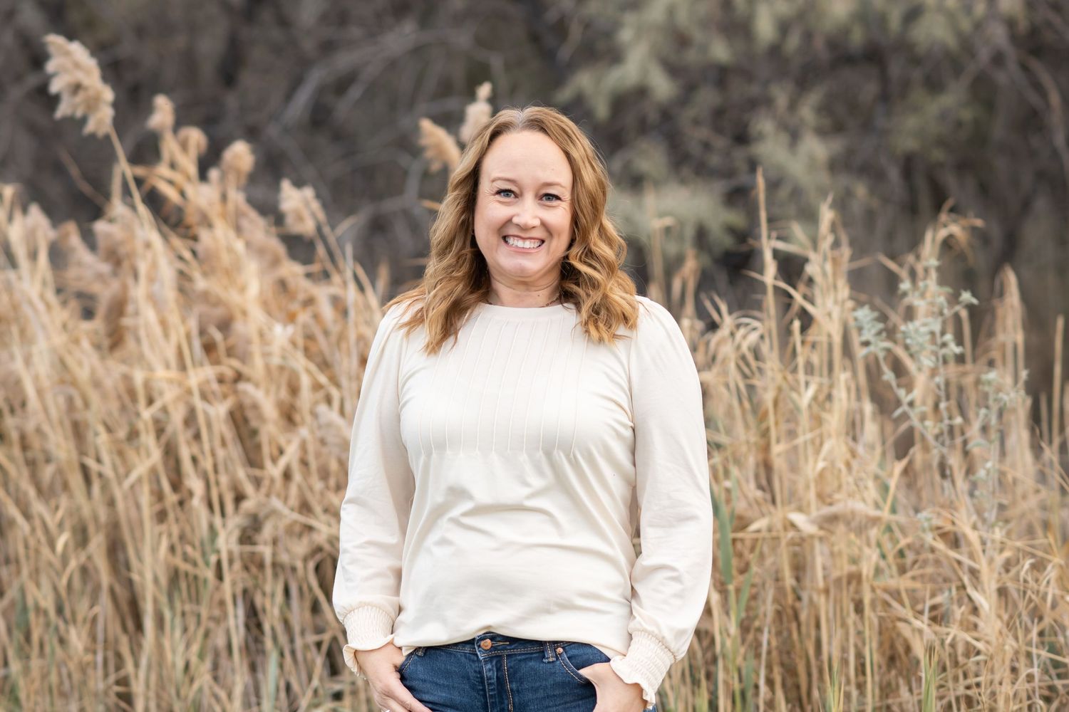 Jen Verbeck, Utah photographer and owner of Jen Verbeck Photography, smiling during an outdoor portrait session.