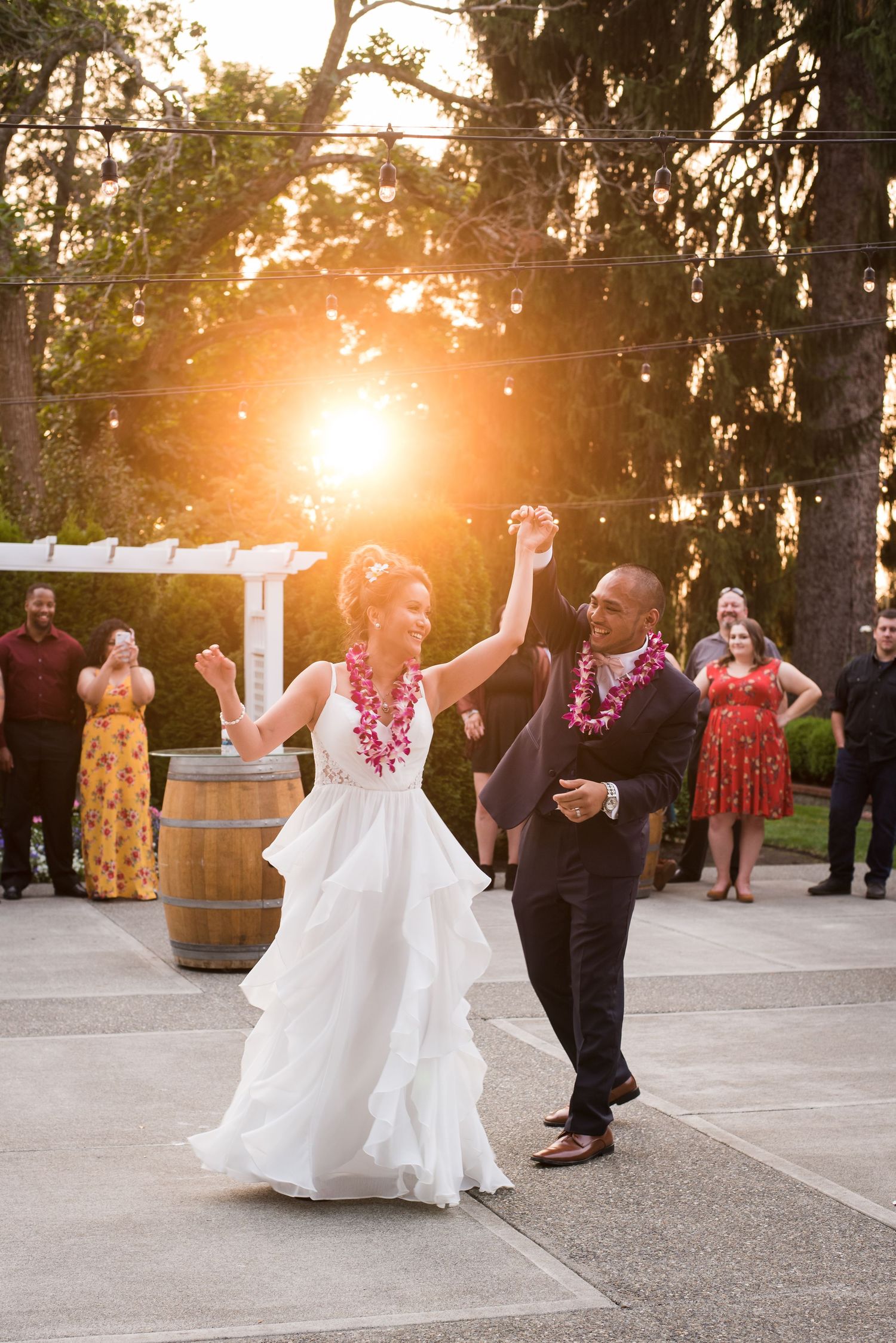 Natural light wedding portrait capturing newlyweds  dancing with golden sunlight shining through the trees.