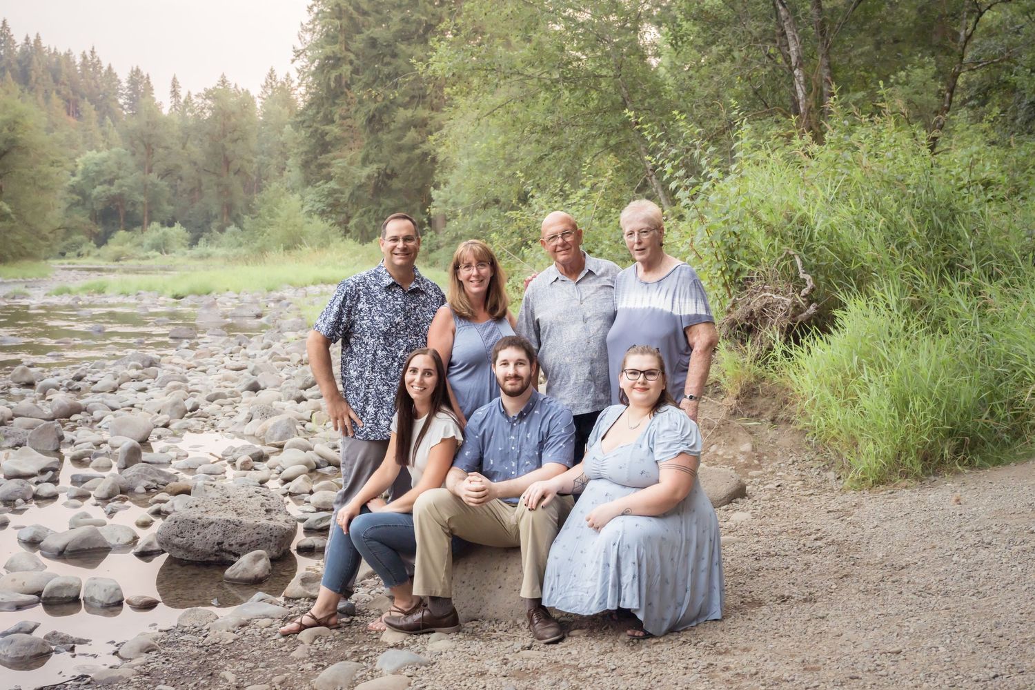 Extended family gathered beside a peaceful river for a relaxed outdoor family photography session at Lewisville Park.