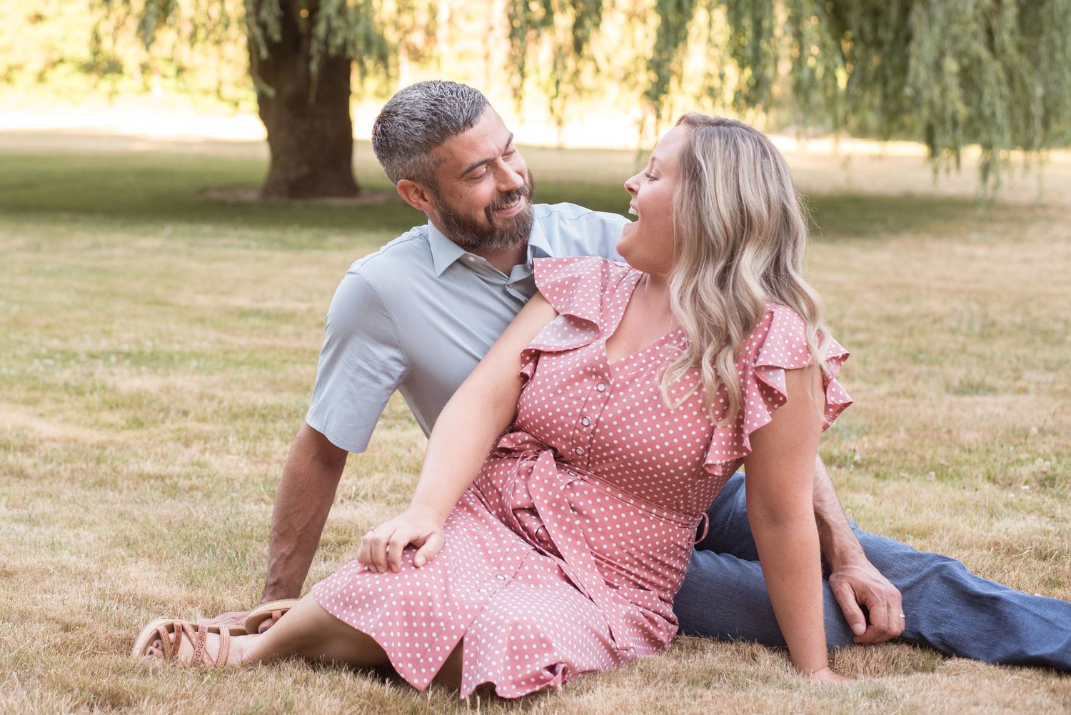 Natural light portrait featuring a couple sharing a joyful moment in a scenic park.