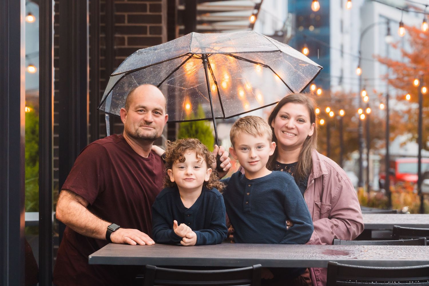 Family gathered together at an outdoor restaurant during a relaxed lifestyle family photography session.