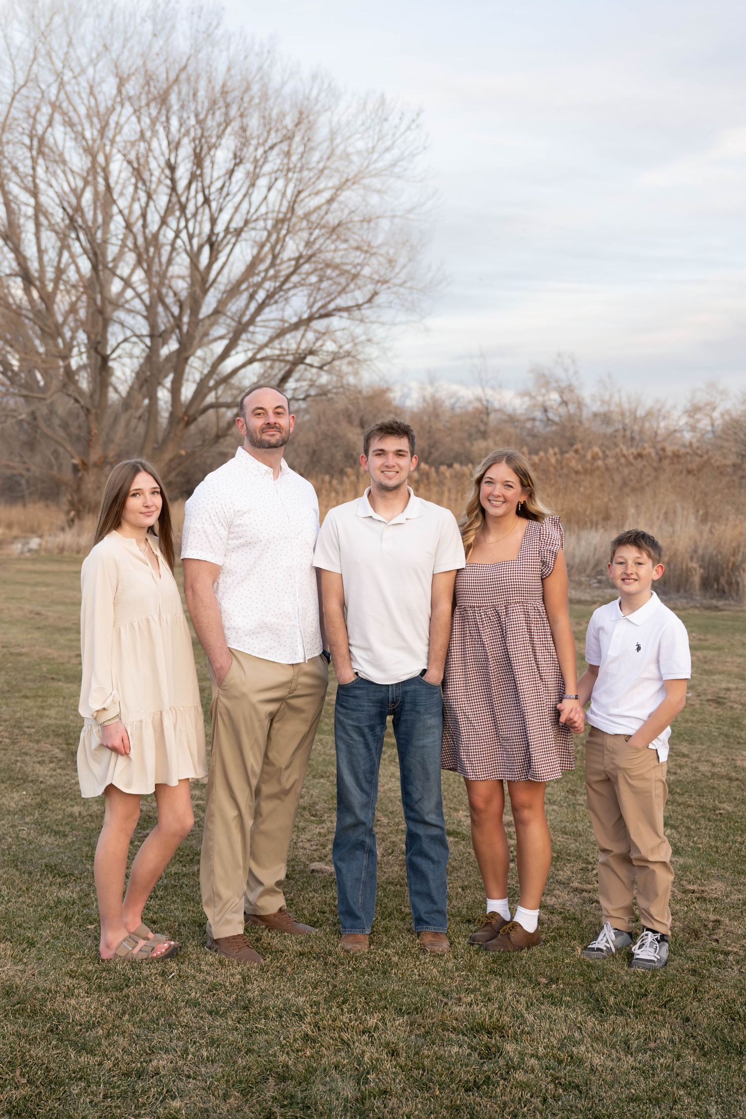 Family of five posing together during a relaxed outdoor family portrait session.