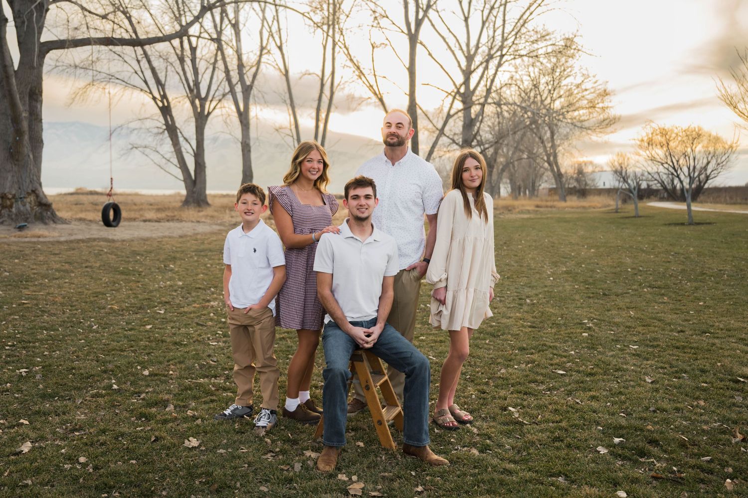 Family gathered together at sunset during an outdoor portrait session, capturing genuine smiles and meaningful moments in Utah.
