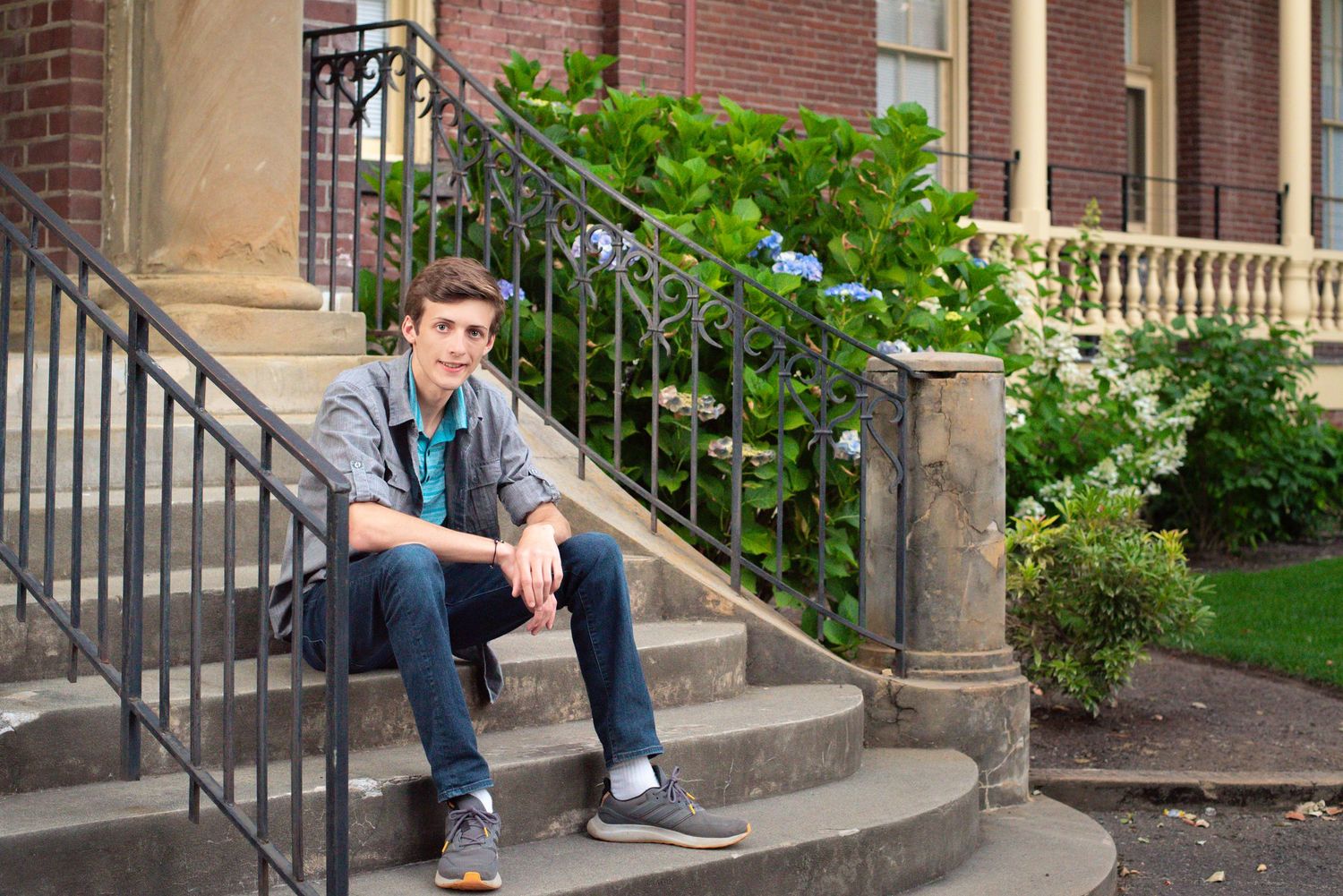 Natural light senior portrait featuring a young man in a charming historic setting.