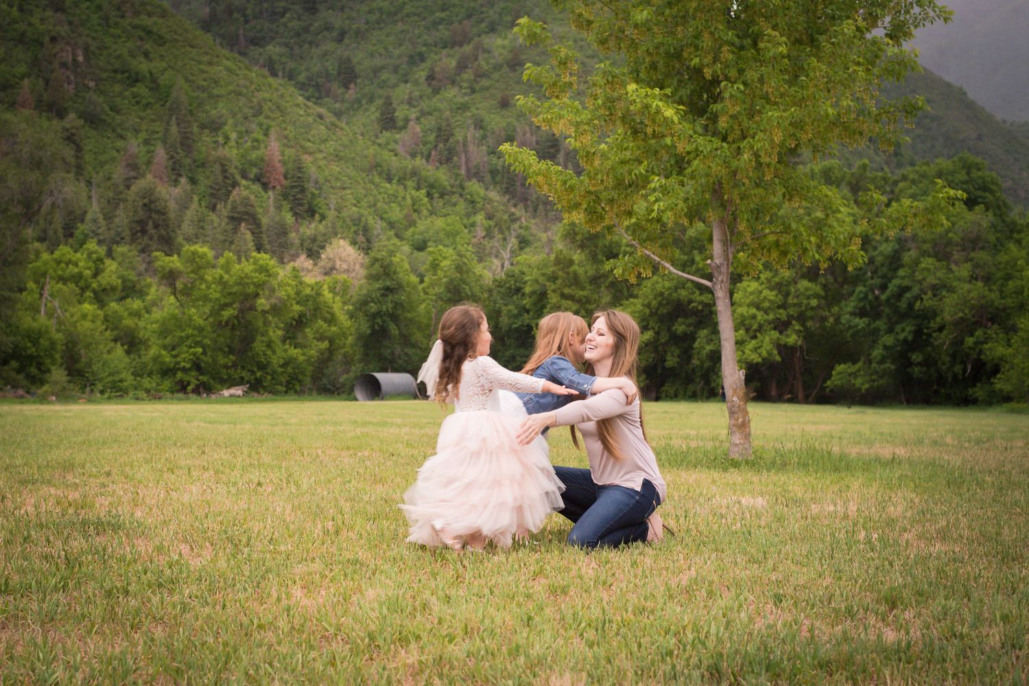 Mother and daughters sharing a joyful moment during an outdoor family photography session in Utah.