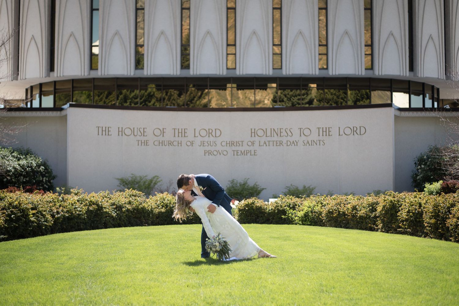 Bride and groom sharing a romantic moment outside the LDS temple after their wedding ceremony.