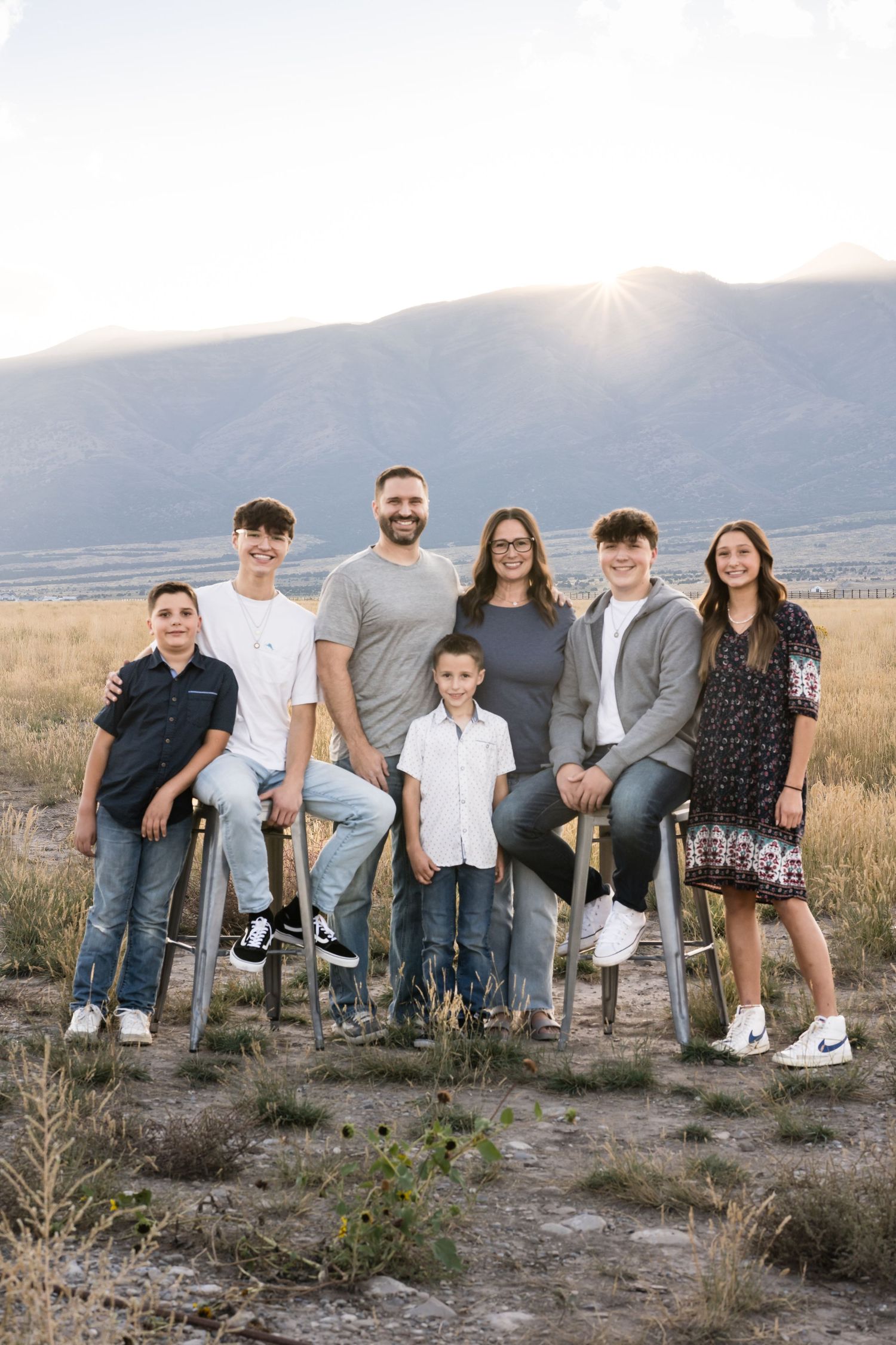 Natural light family portrait captured in a scenic mountain landscape at sunset.