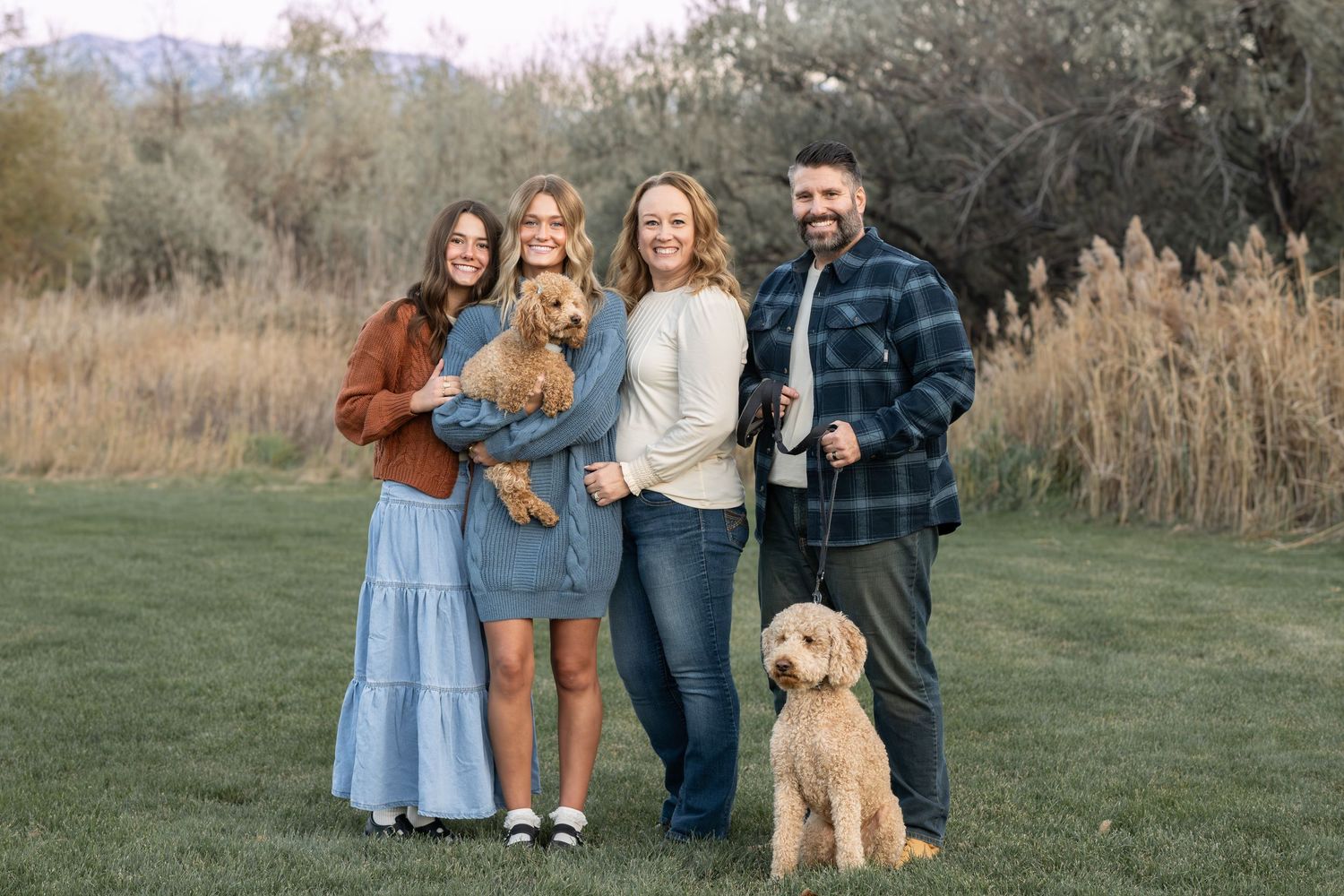 Family portrait with their Goldendoodle during a beautiful outdoor lifestyle photography session in Utah County.