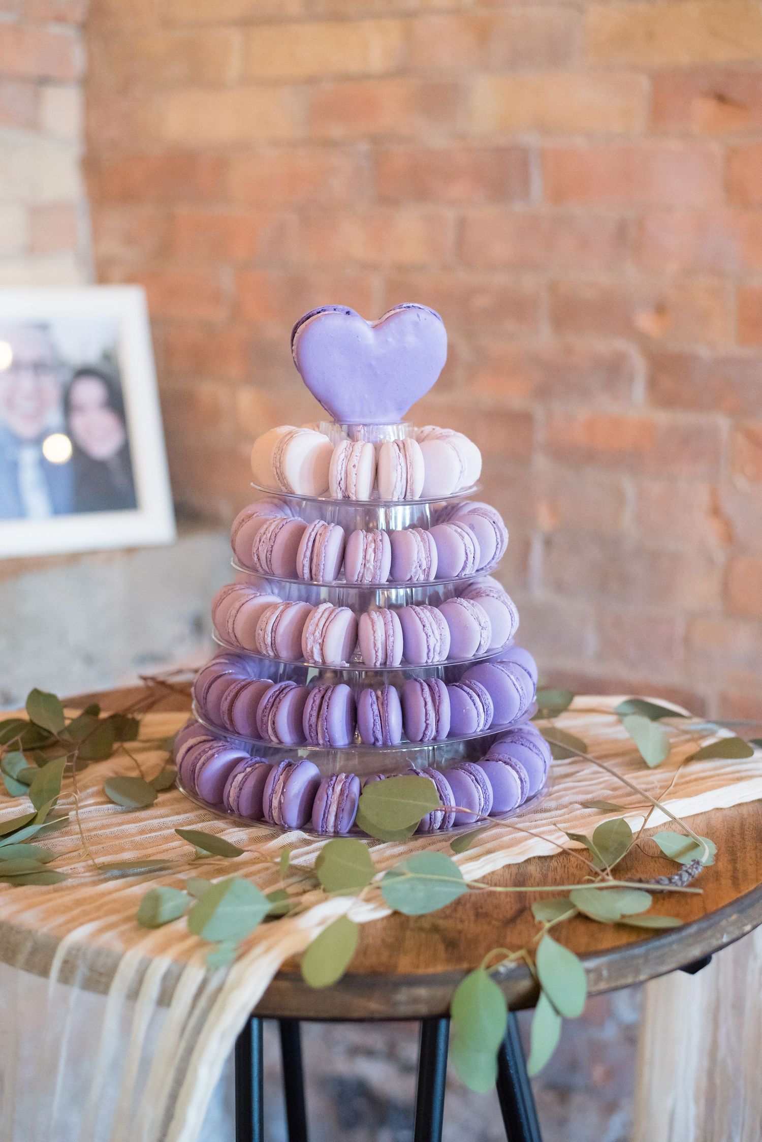 Elegant wedding dessert display featuring a beautifully decorated macaron tower at the reception.