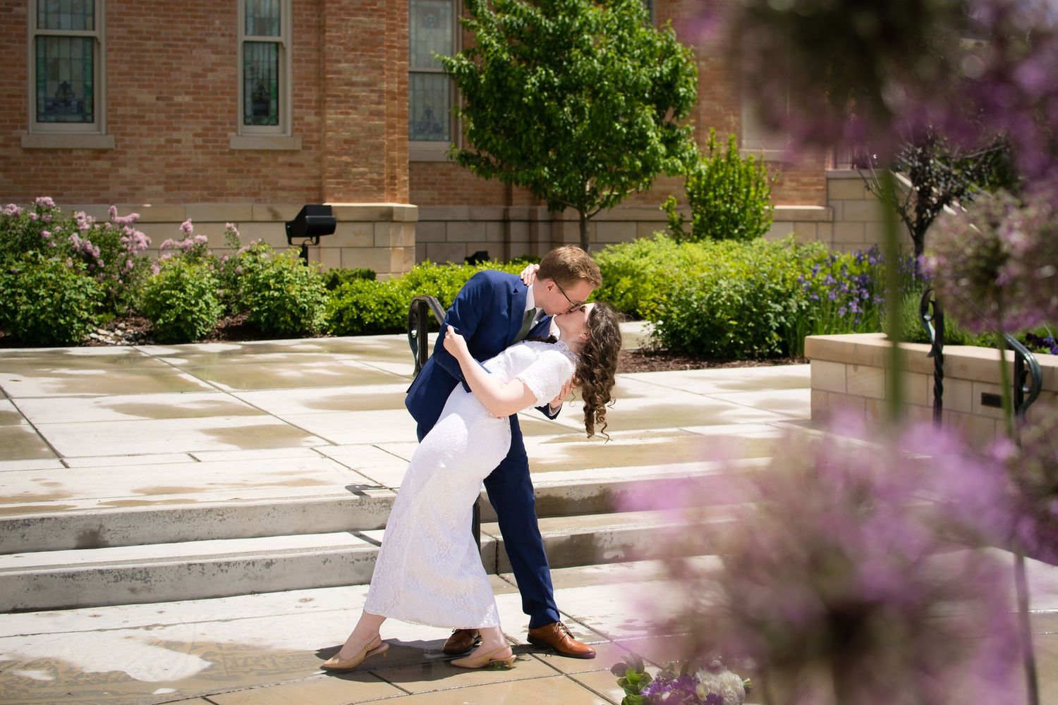 Bride and groom sharing a romantic kiss outside the LDS temple on their wedding day.