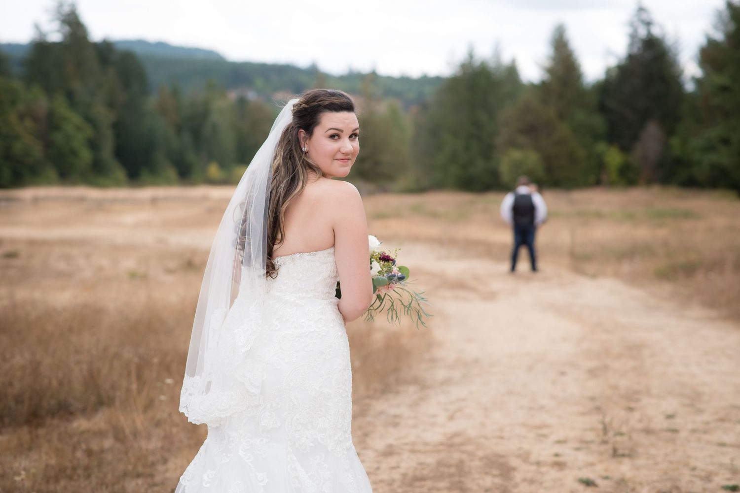 Bride peeking over her shoulder before the first look.