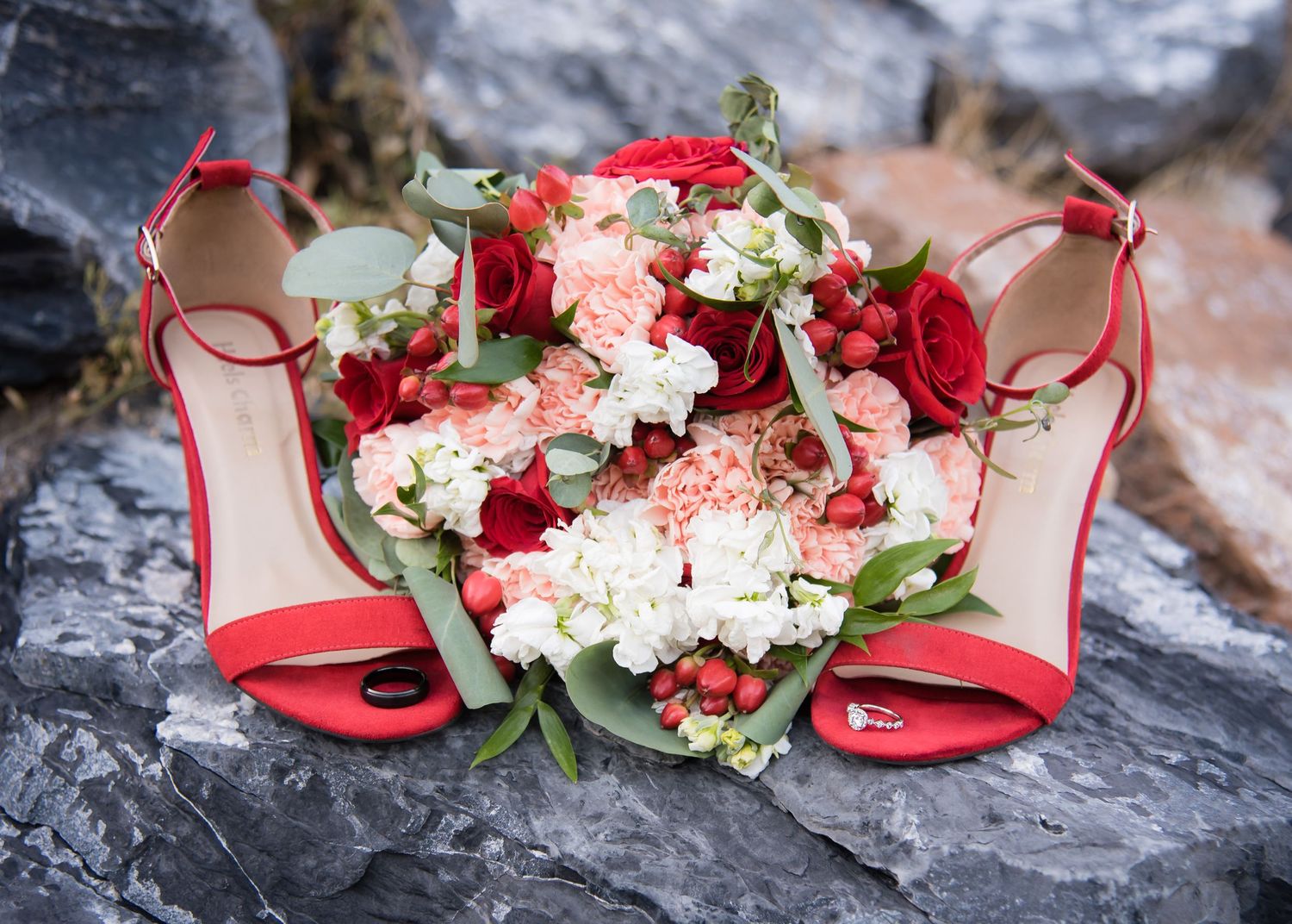 Wedding bouquet and red bridal heels beautifully styled for a detailed wedding flat lay.