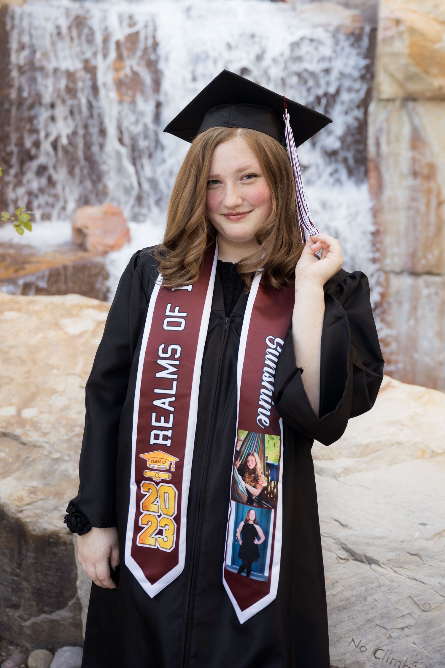 High school graduate wearing a cap and gown during a graduation photography session in Utah.