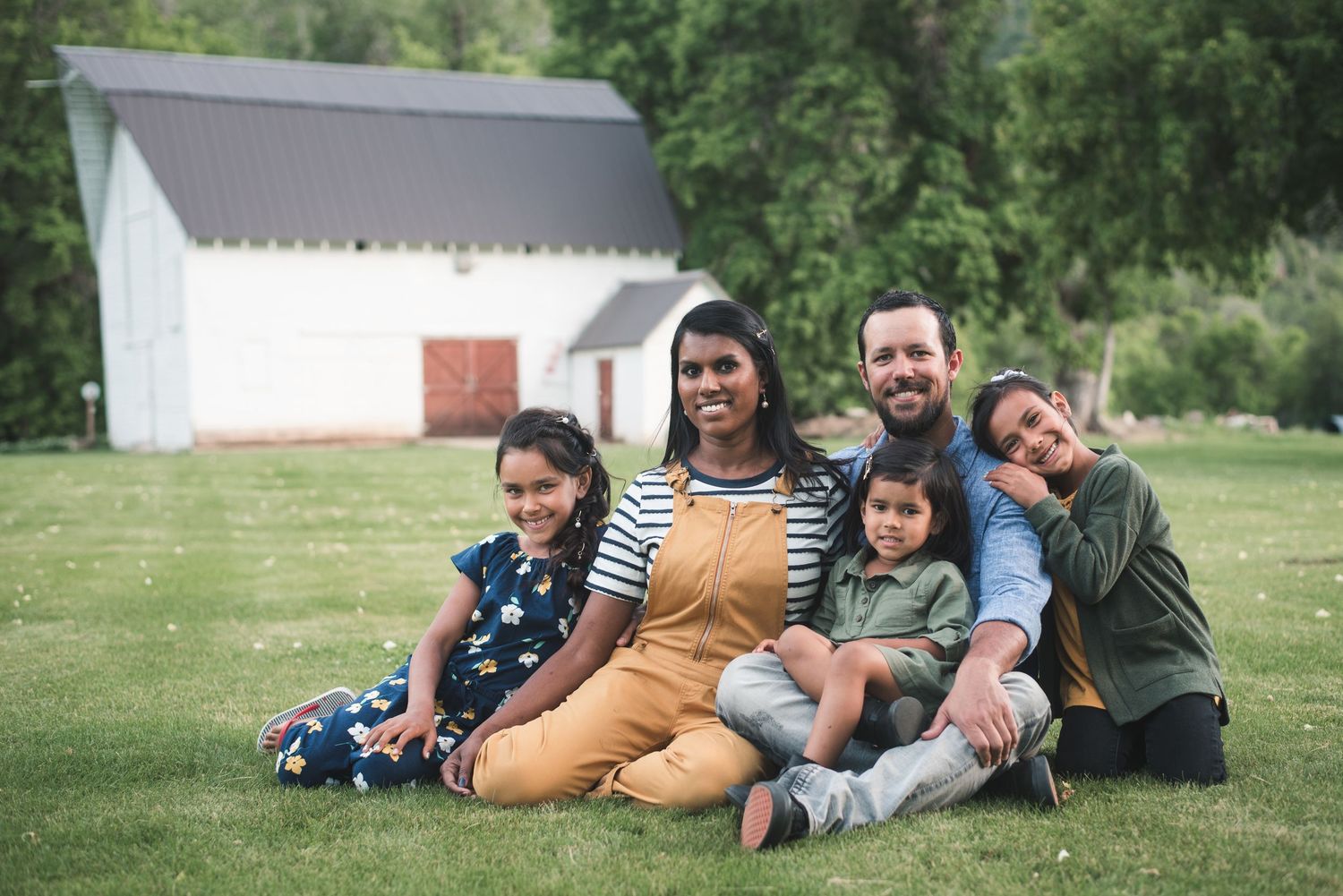 Family of five smiling together during an outdoor family photography session in Utah.