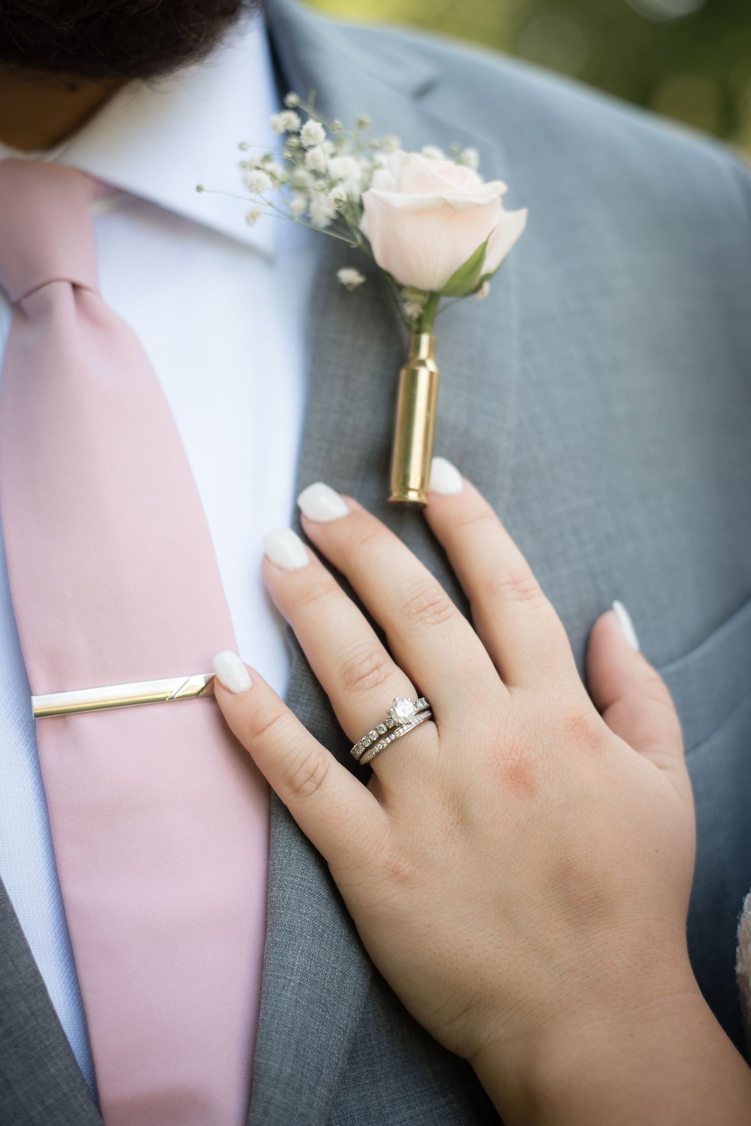 Close-up of the bride's wedding ring and groom's boutonniere during the wedding celebration.