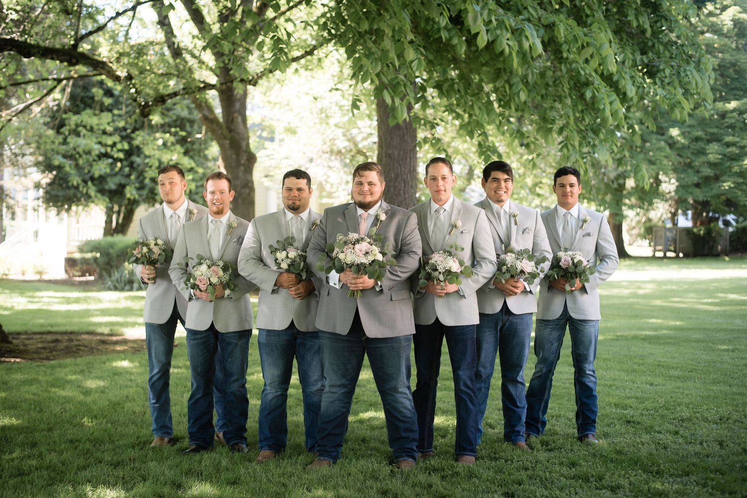 Groomsmen posing together during an outdoor wedding party portrait before the ceremony.