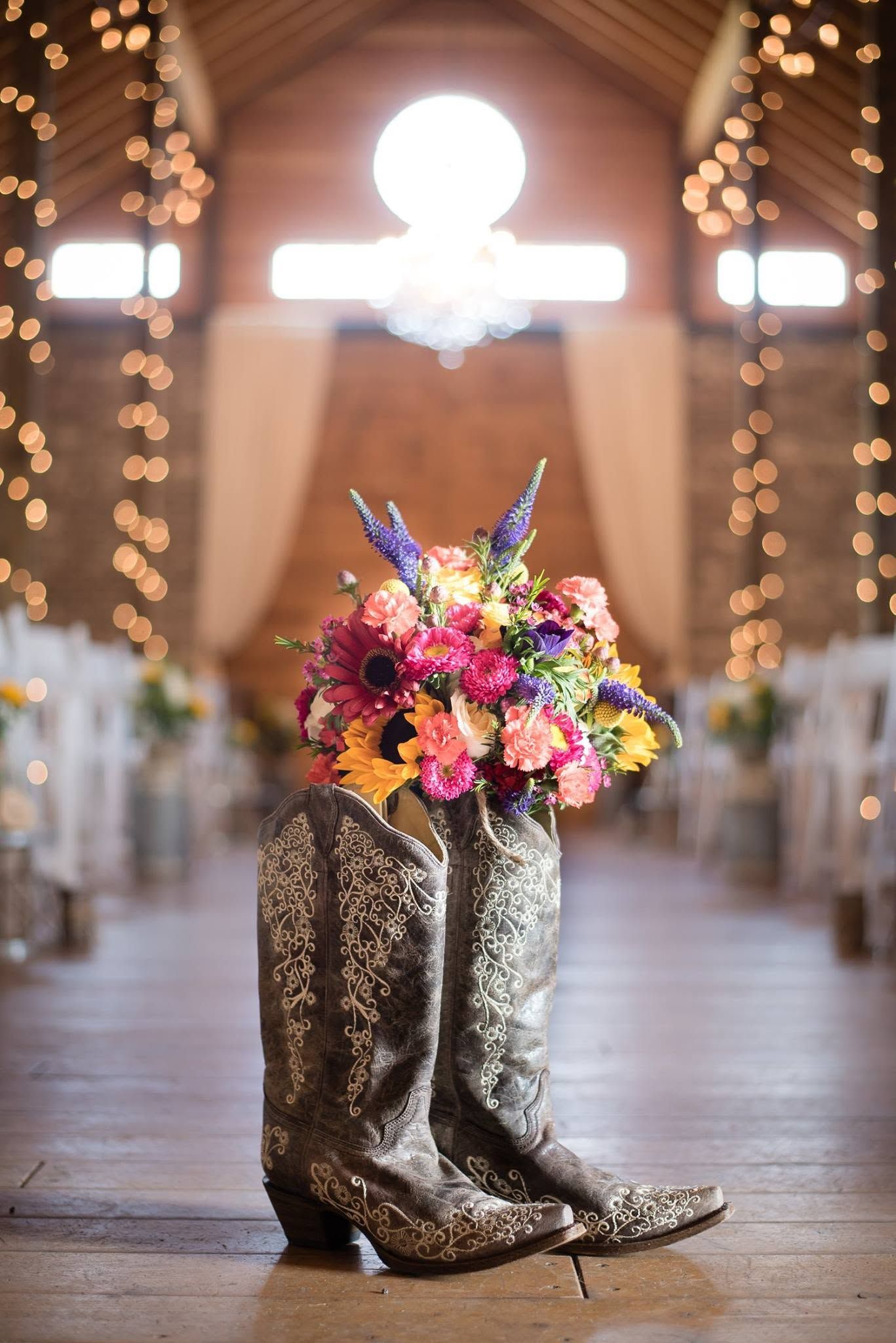 Wedding details featuring cowboy boots and bridal bouquet in a rustic church setting.