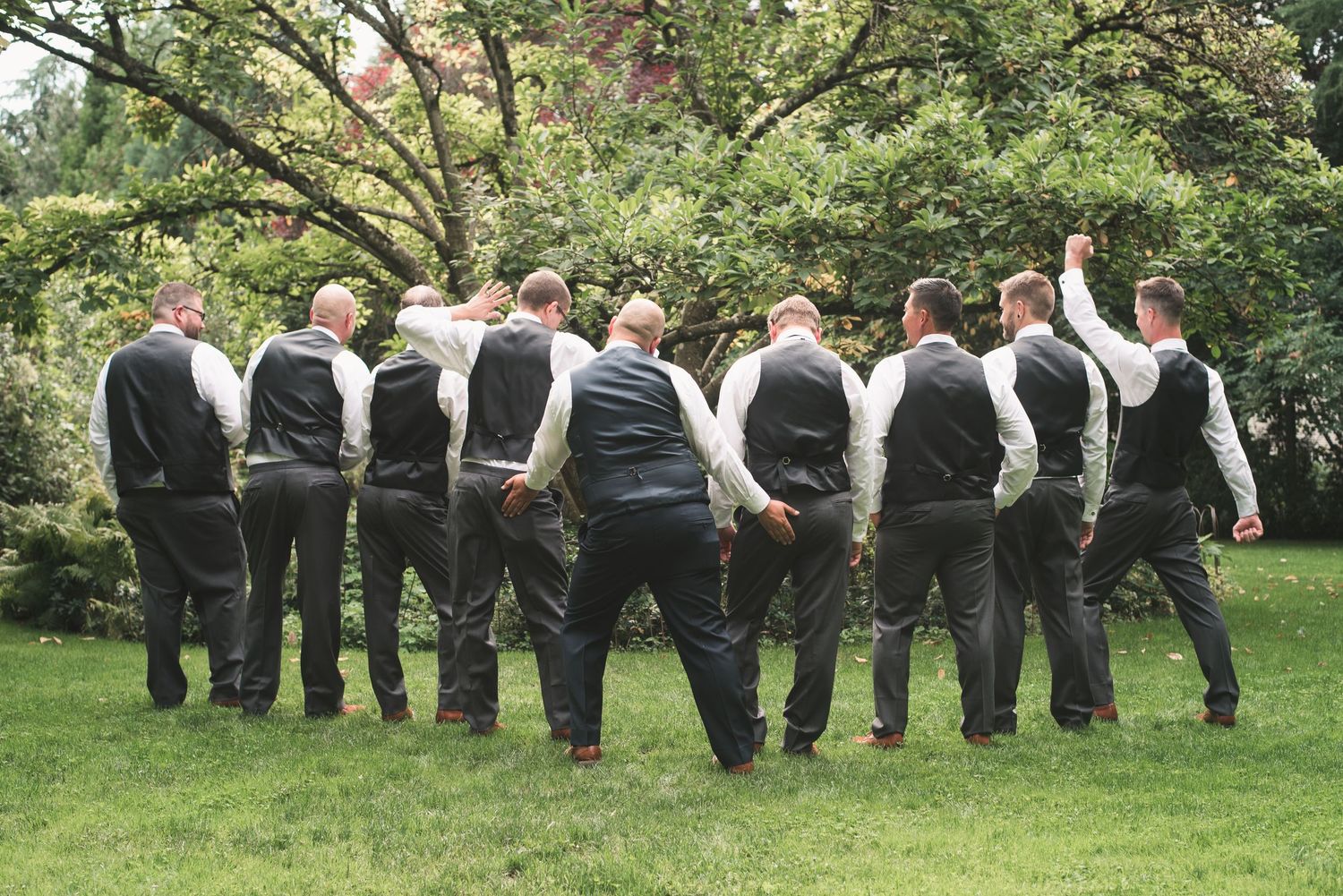 Groom and groomsmen standing together during an outdoor wedding photography session.