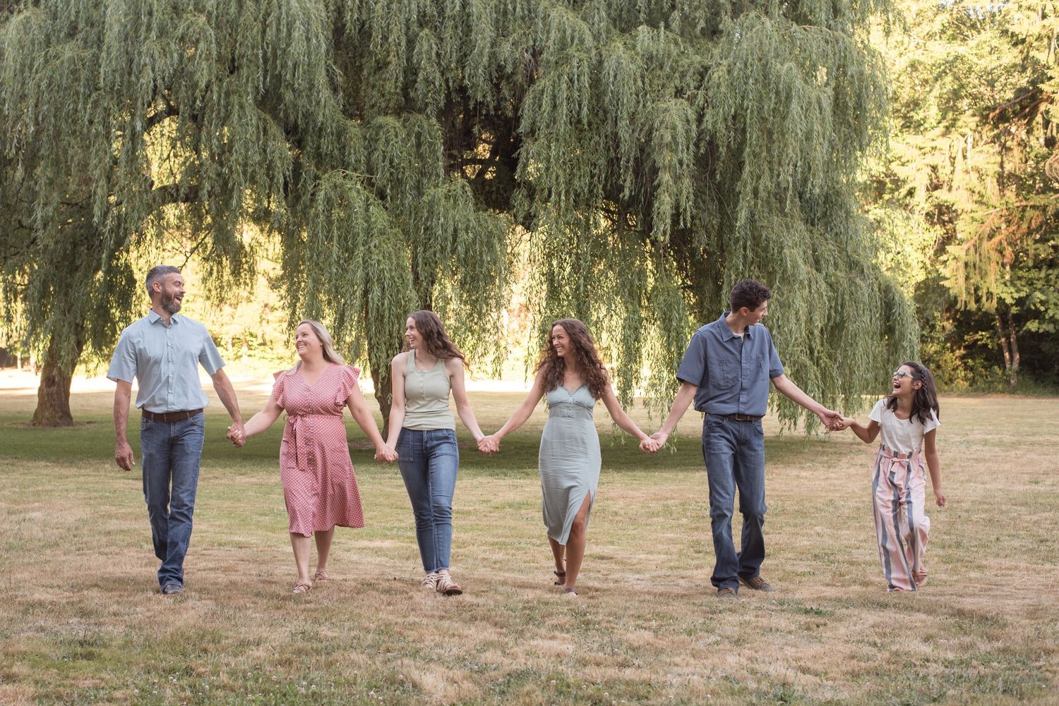 Natural light family portrait capturing genuine connection in a beautiful park setting.