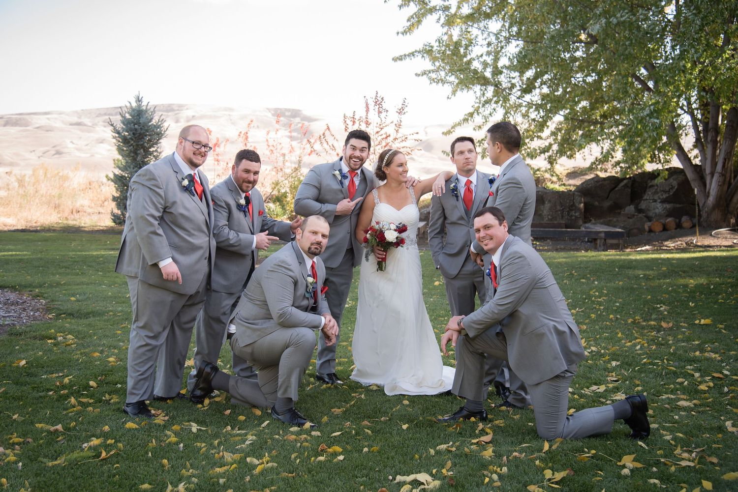 Bride and groom celebrating with their wedding party during a fun outdoor wedding portrait.