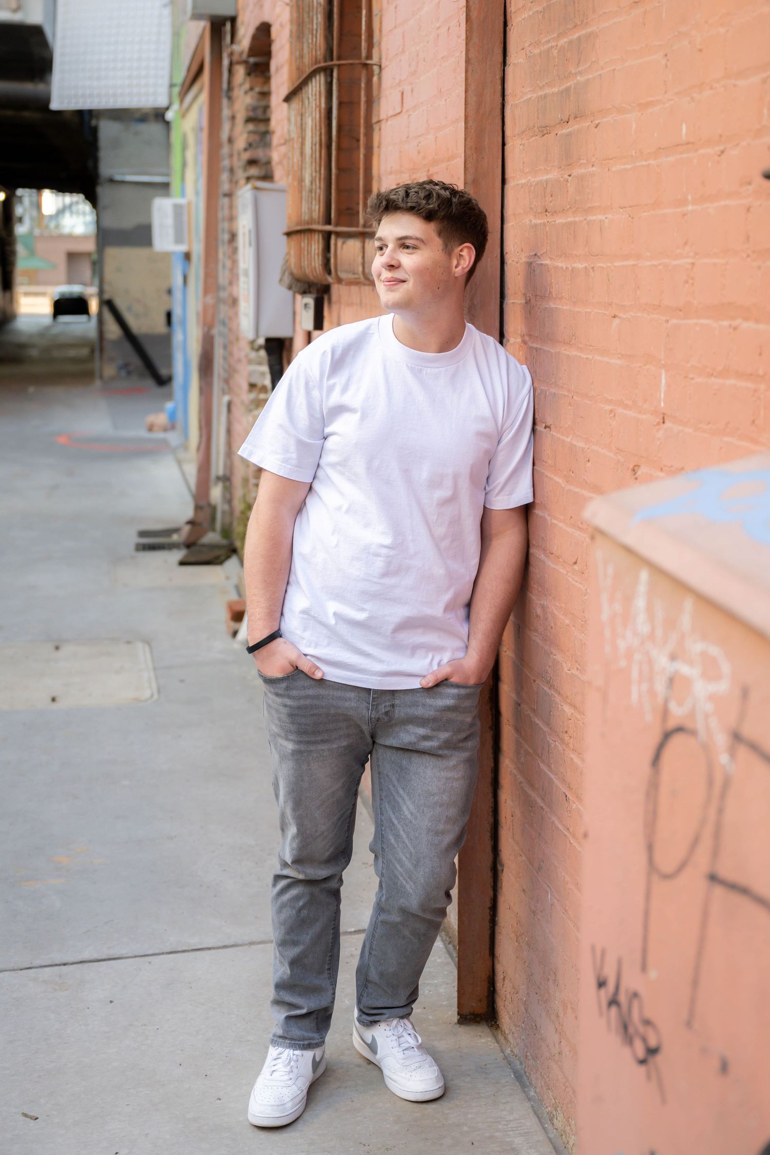 Natural light senior portrait featuring a young man in a downtown setting.
