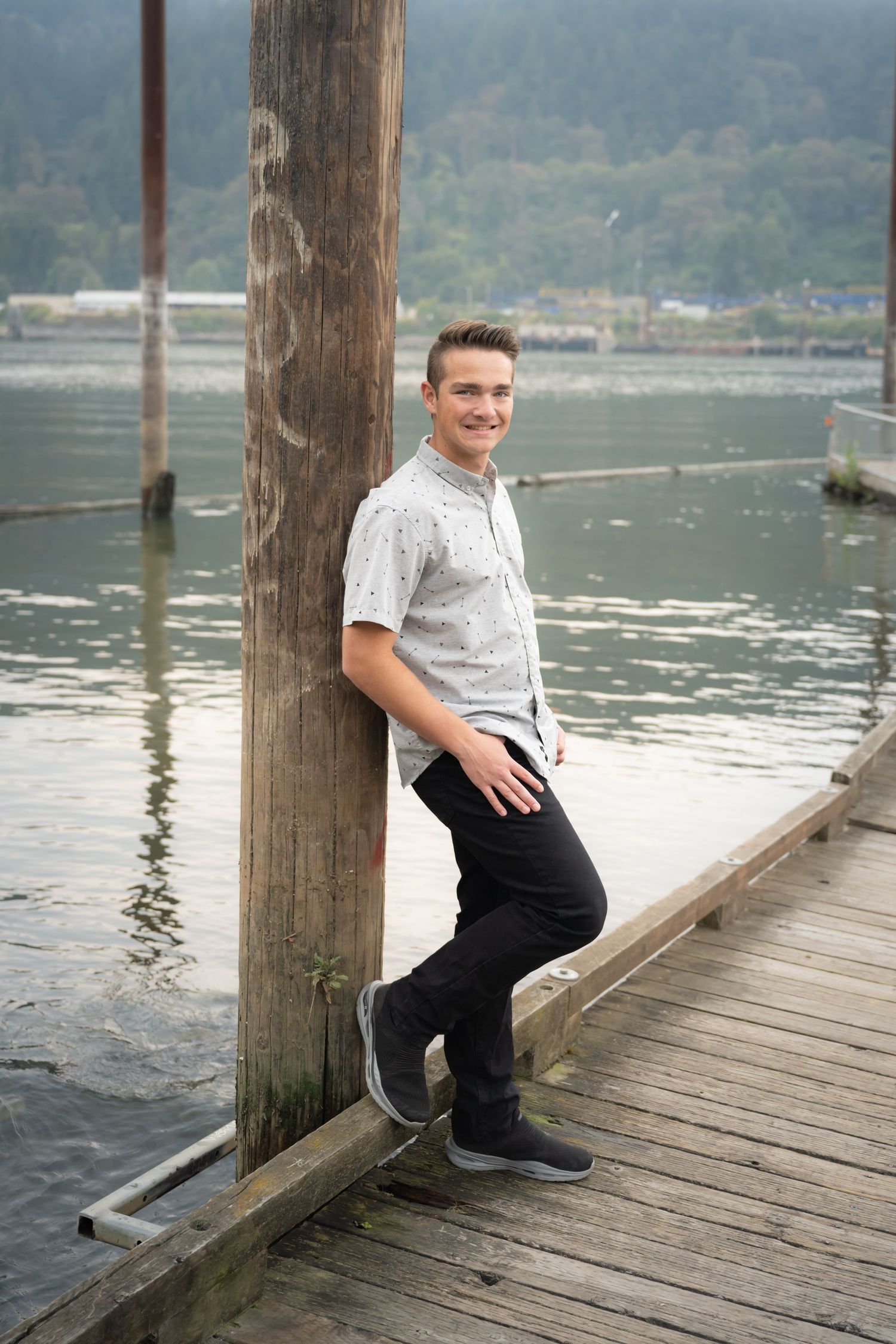High school senior boy posing on a dock during an outdoor senior photography session in Oregon.