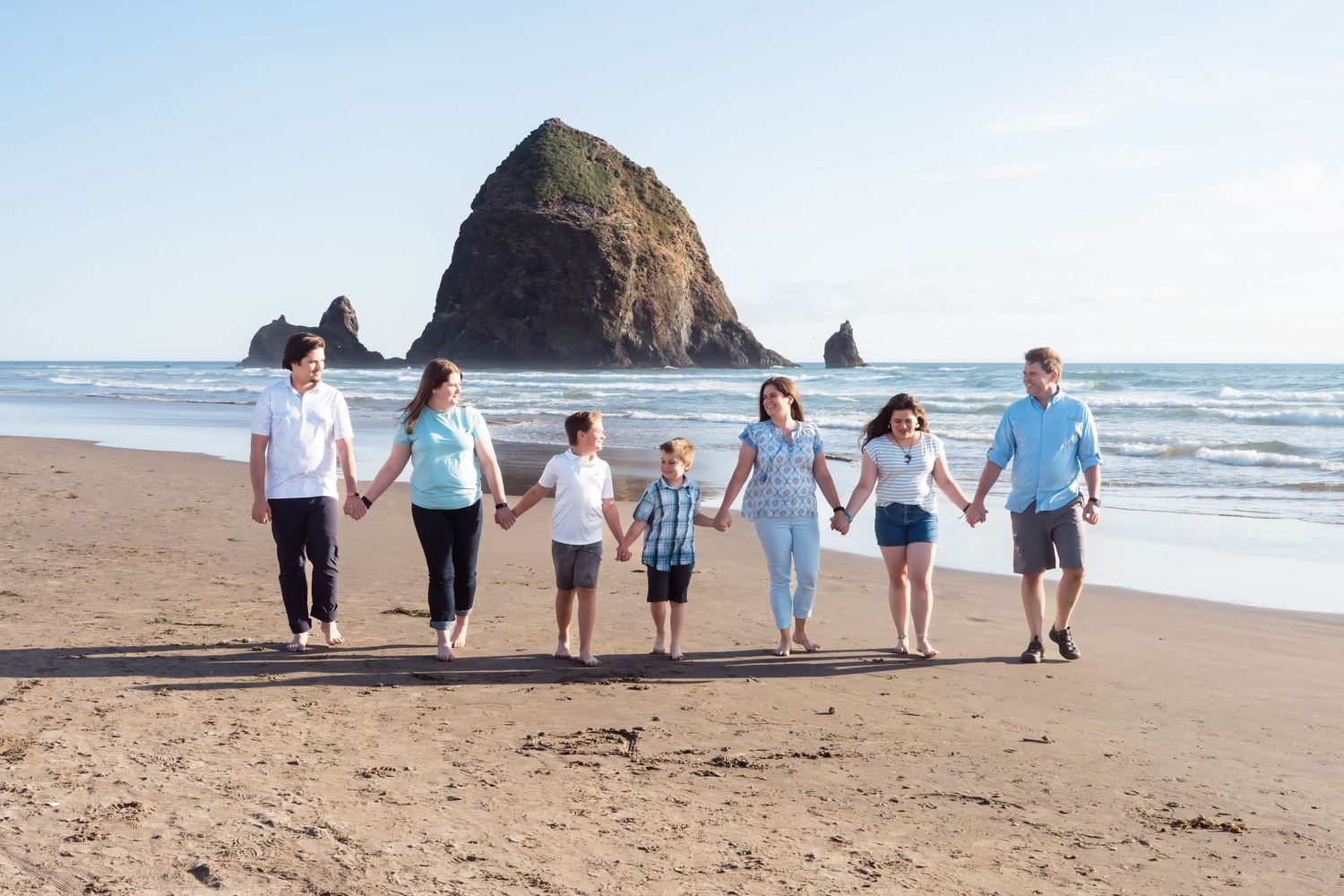Family of five walking together on Cannon Beach during an outdoor family photography session by Jen Verbeck Photography.