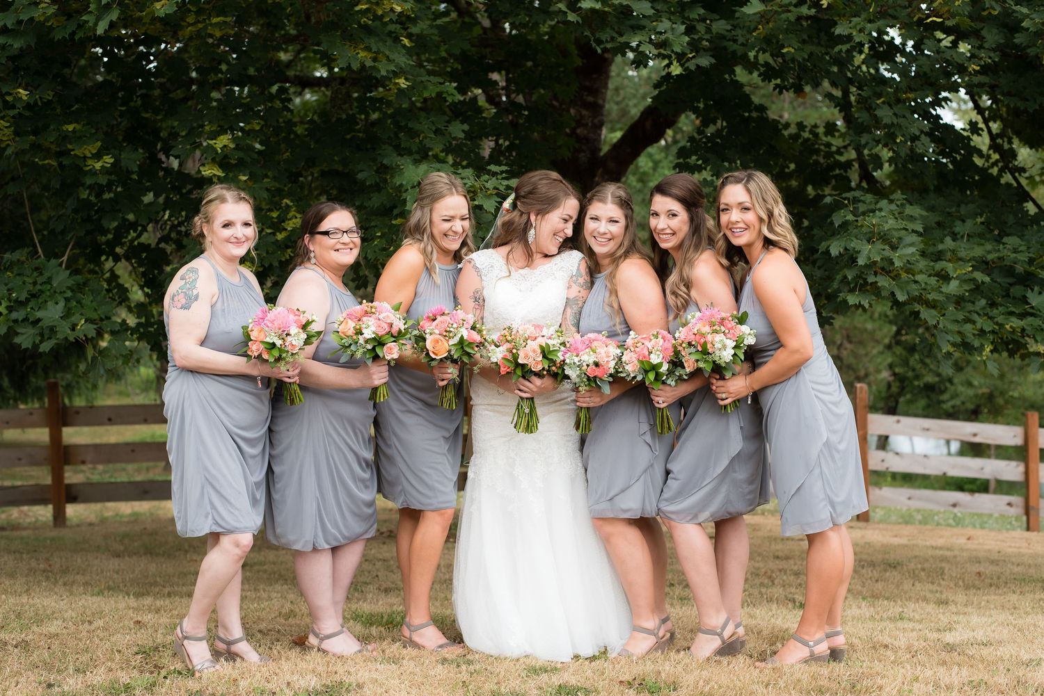 Bride and bridesmaids sharing a joyful moment before the wedding ceremony during a beautiful outdoor wedding photography session.