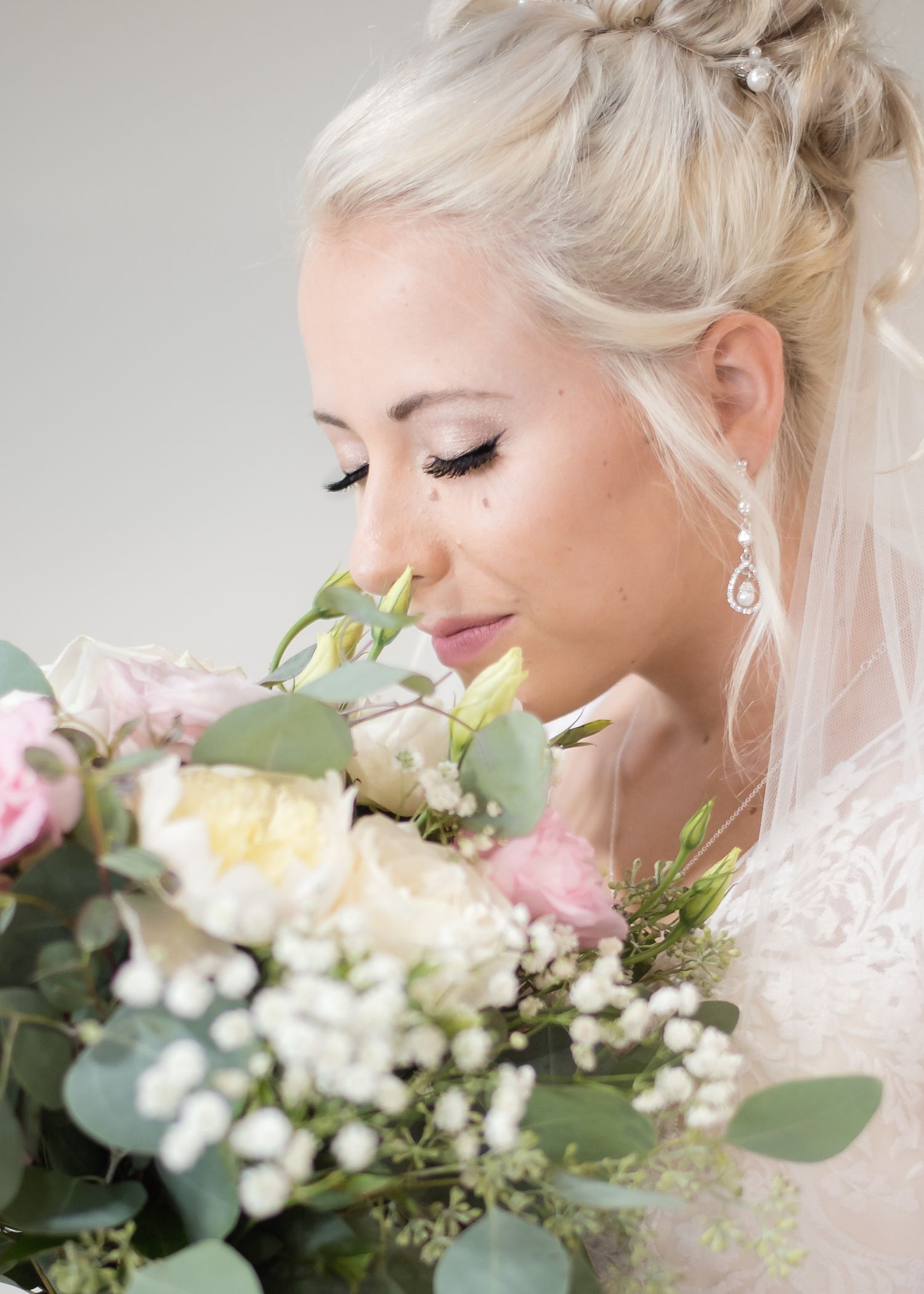 Close-up bridal portrait featuring the bride holding her bouquet with soft natural light.