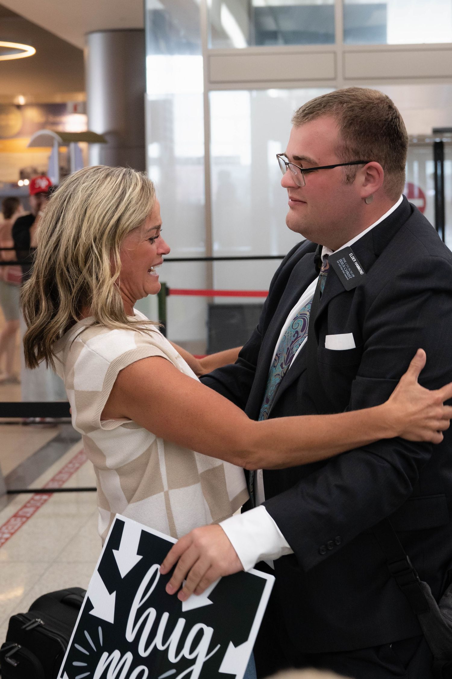 Emotional LDS missionary airport homecoming as mom and missionary shares their first hug after returning from service at the SLC airport..