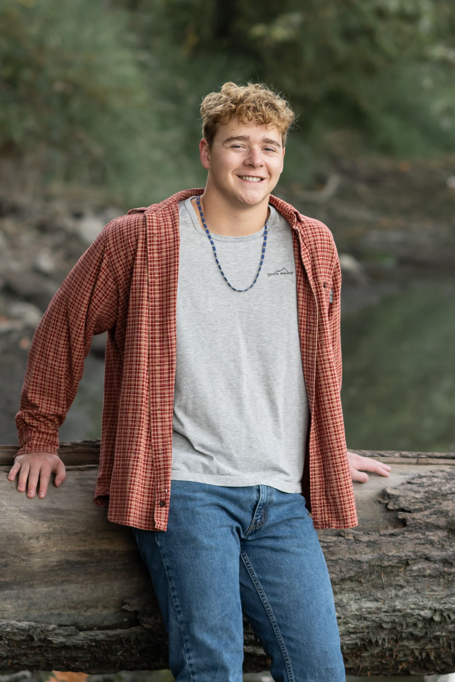 High school senior boy posing outdoors in casual clothing during a relaxed natural light senior portrait session in Utah.