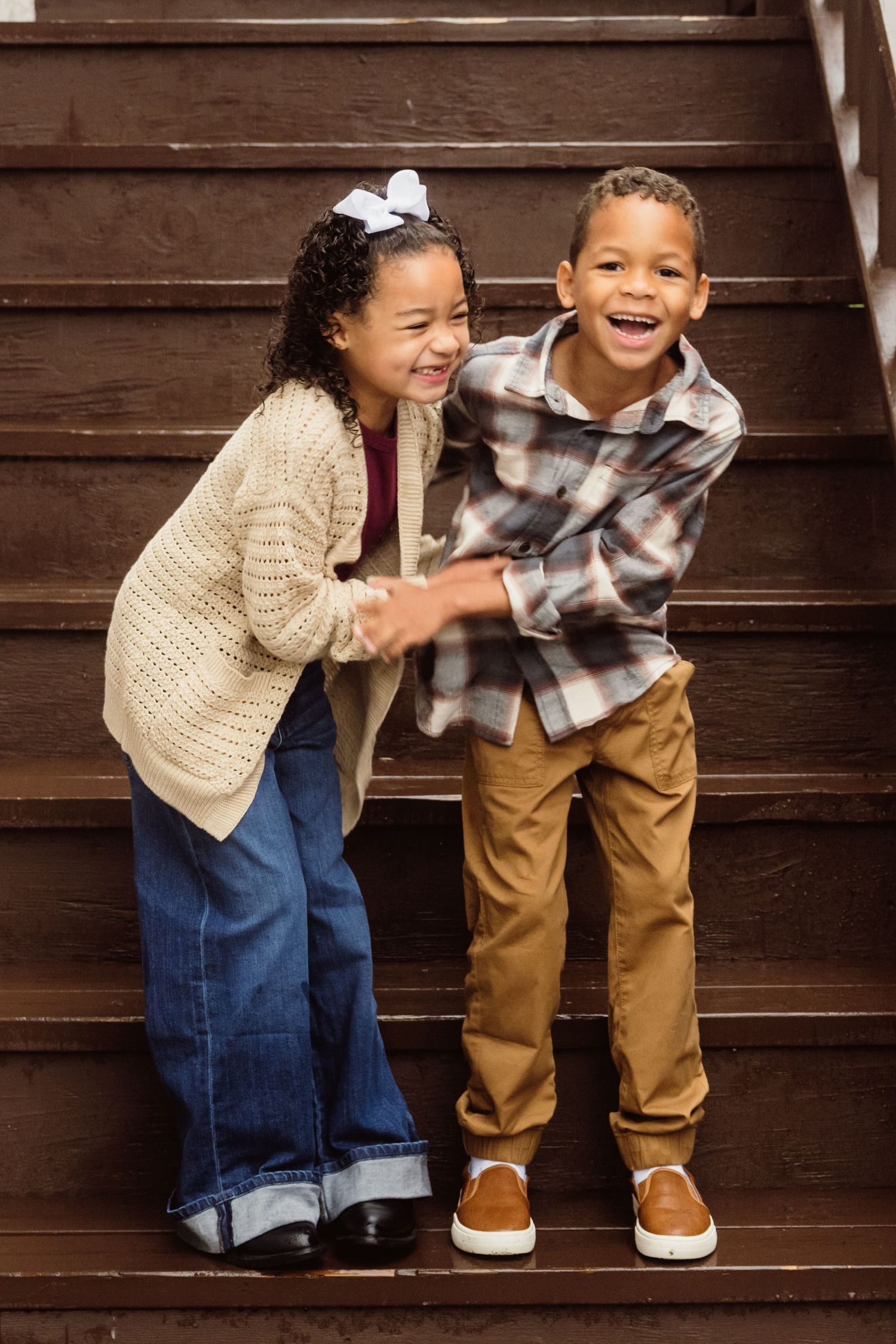 Twins sharing a joyful moment during a warm lifestyle family photography session.
