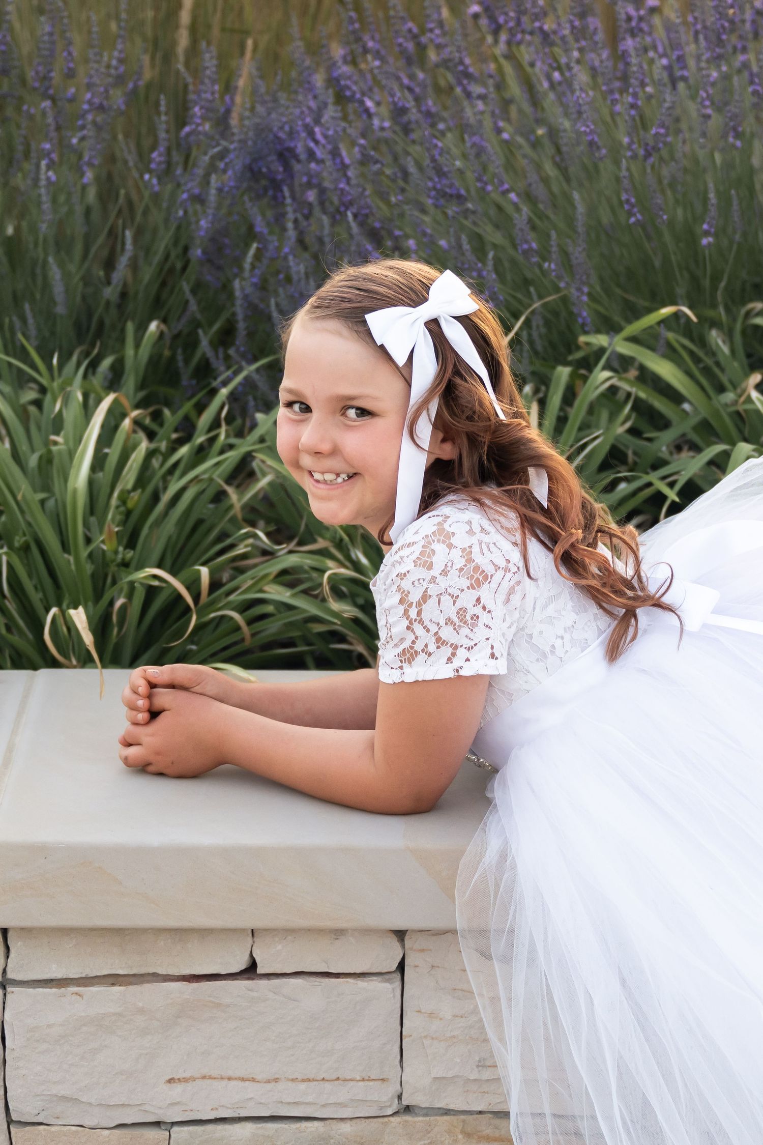 Young girl smiling during an outdoor child baptism photography session in Utah.