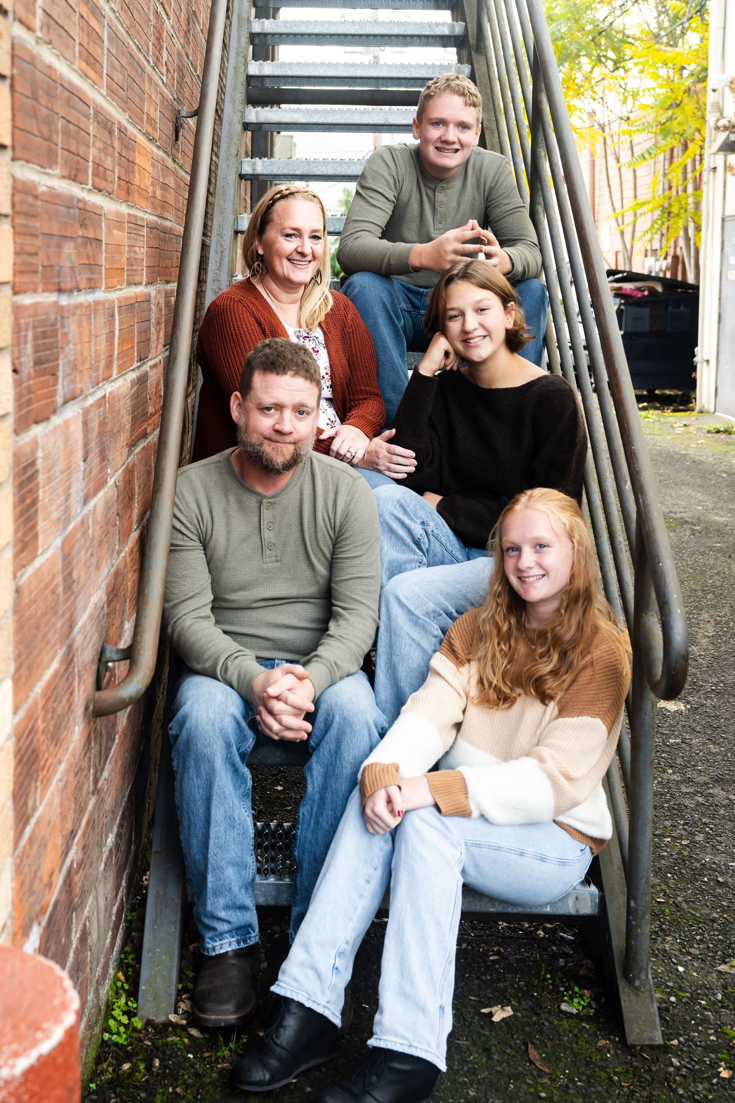 Family gathered on outdoor stairs during a relaxed lifestyle family photography session.