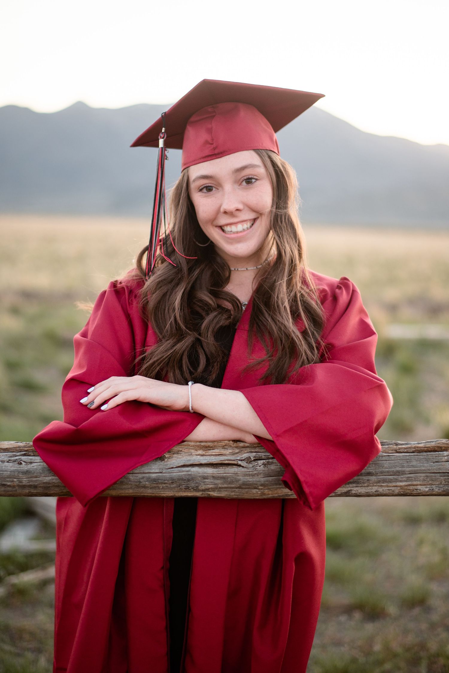 High school graduate wearing a cap and gown during a graduation photography session in Utah.