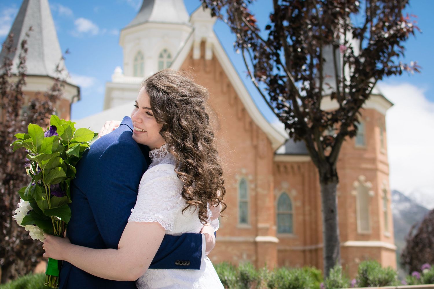 Bride and groom embracing outside the LDS temple during their wedding portrait session.